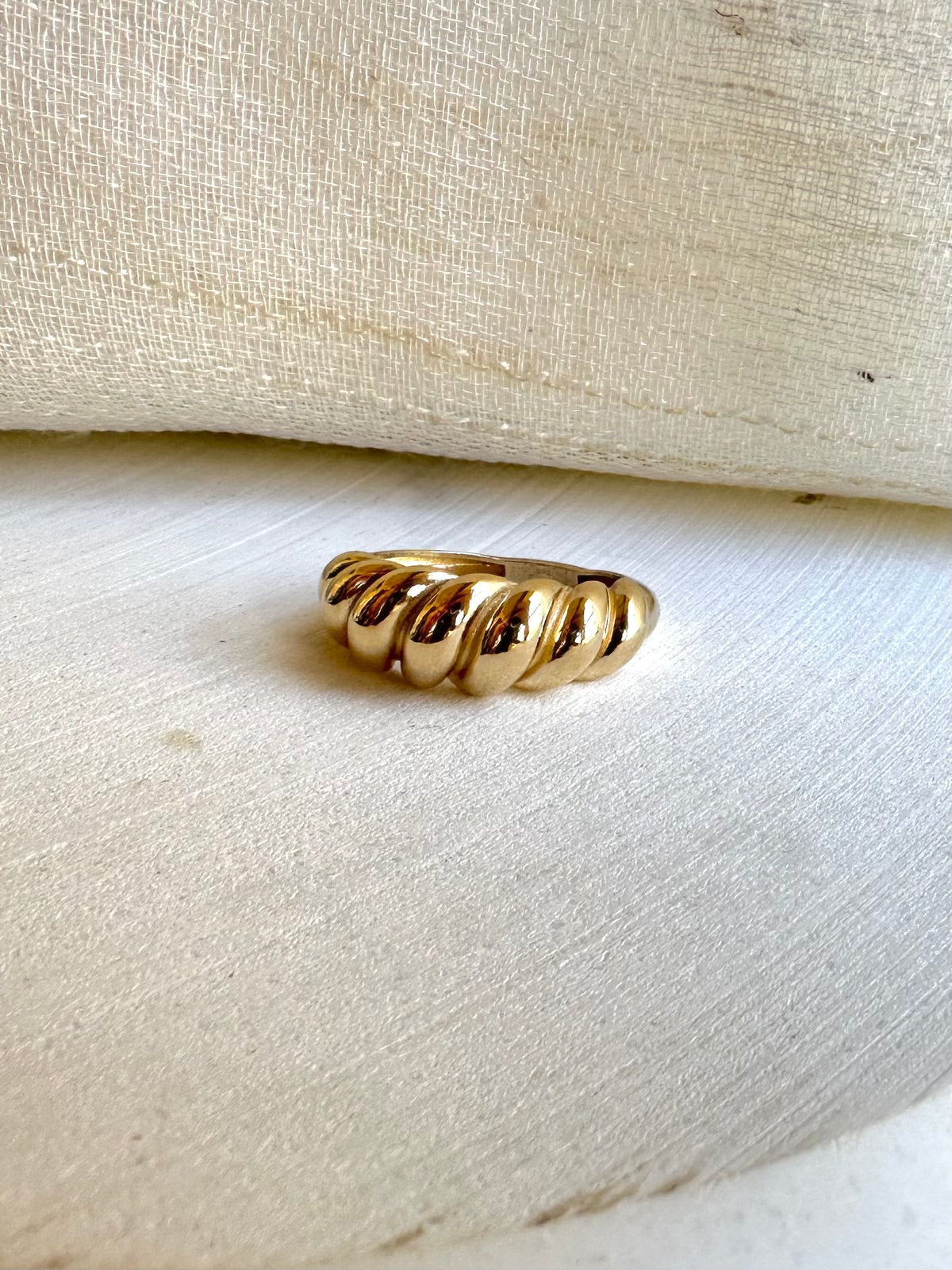 Twisted croissant ring in solid 14K gold worn on a hand
