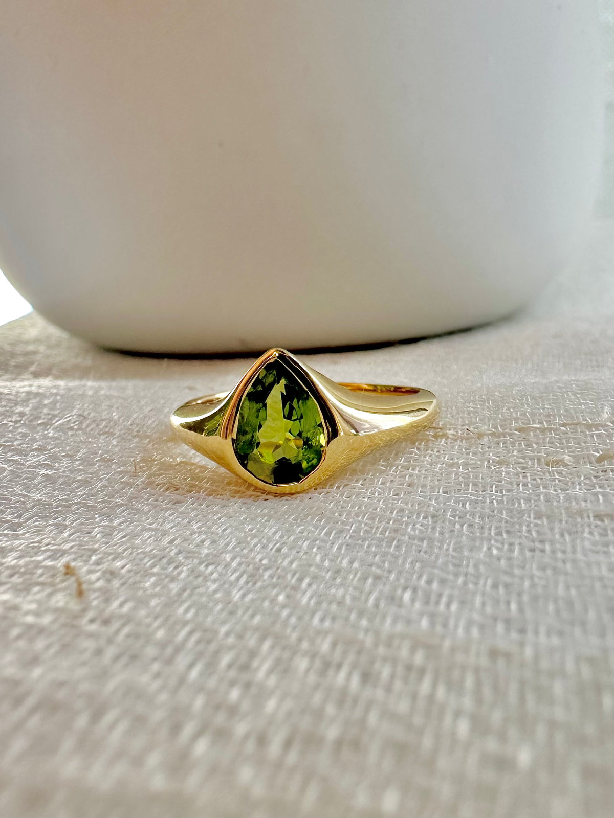 Peridot signet ring with a bezel set pear-cut peridot, the August birthstone