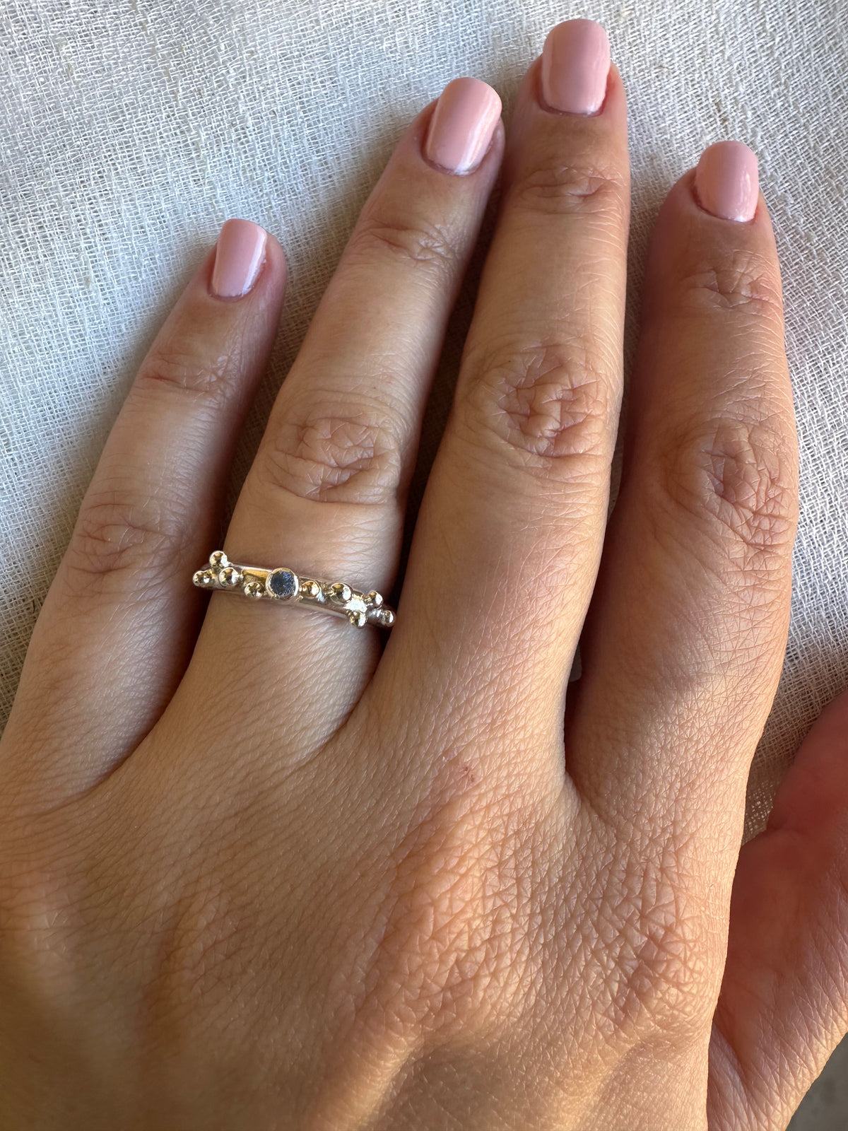 Handcrafted silver ring with silver granulation and a blue sapphire at its center