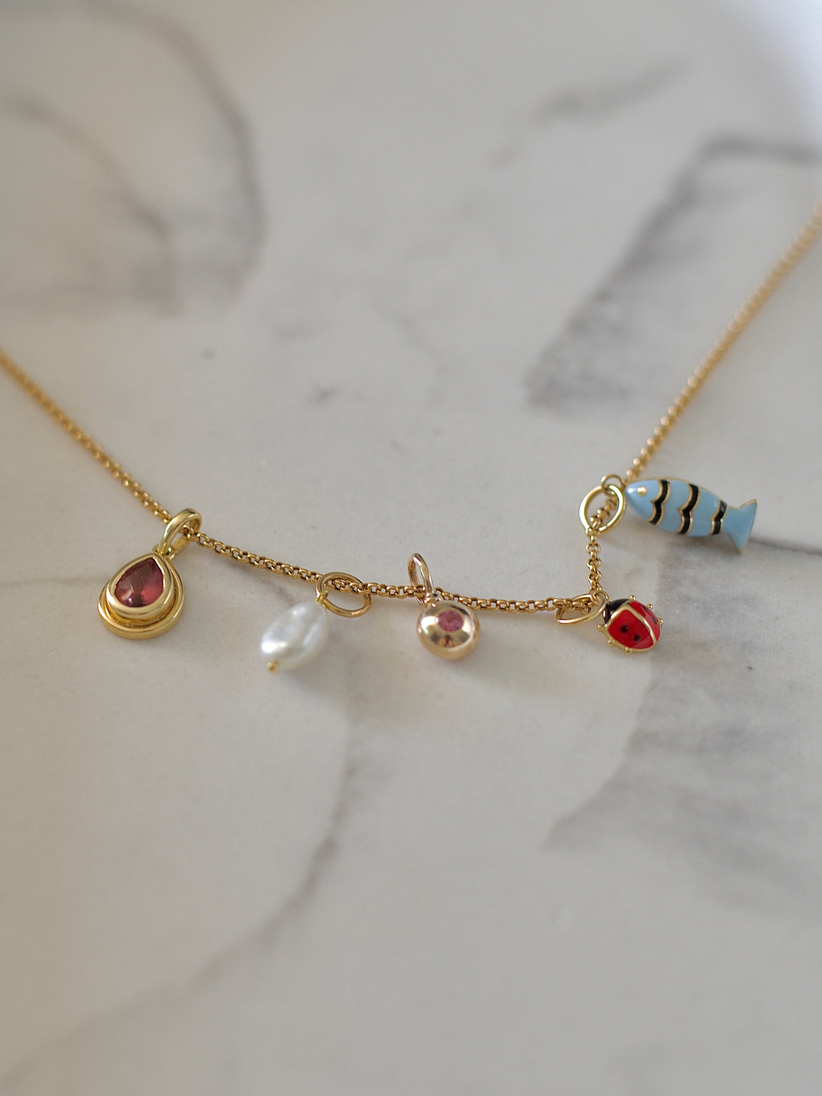 14K gold charm set with a 2.6mm pink sapphire, fourth view