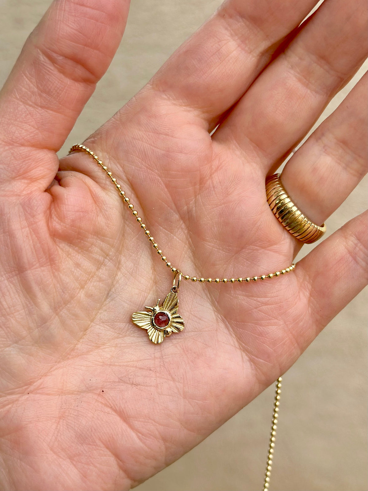 Round pink tourmaline butterfly charm in a gold bezel, 14K or 18K