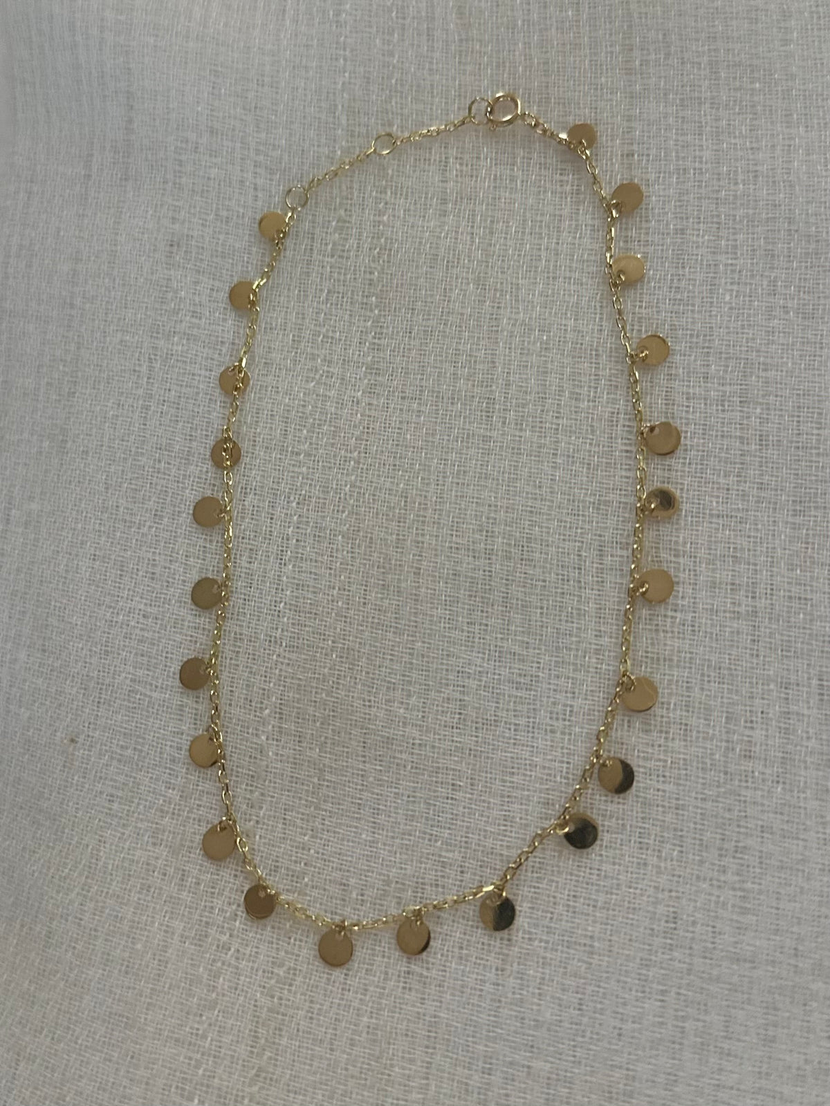 Dainty 18K solid gold coin anklet with disc charms, worn on the ankle
