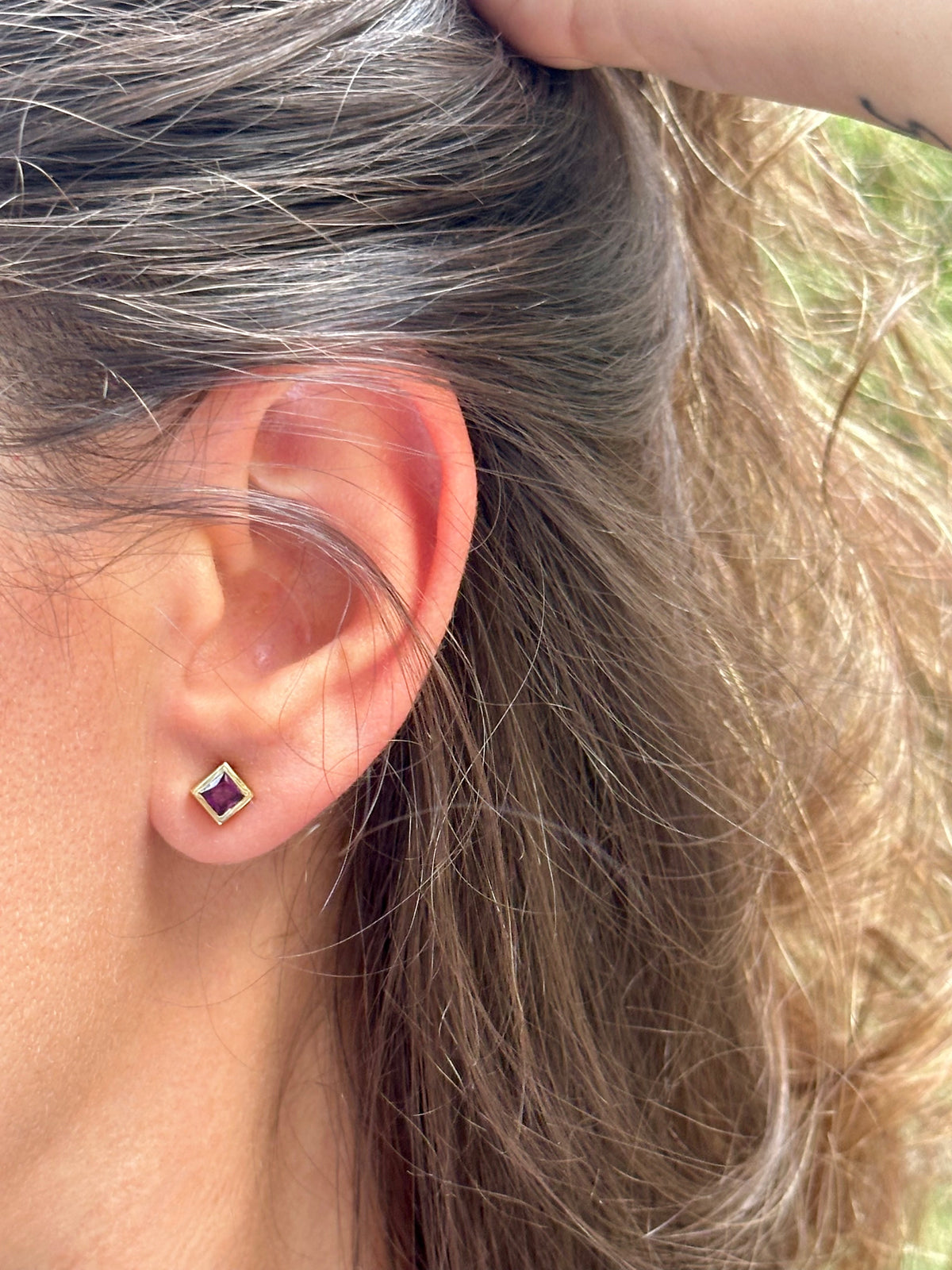 Garnet studs whose color shifts from fuchsia to purple under different lighting