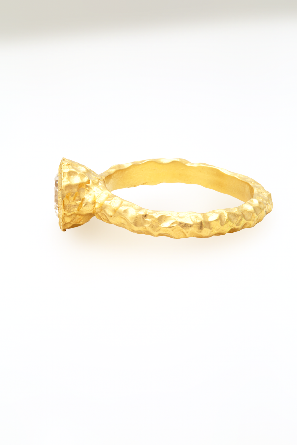 Glypto Solitaire Ring, side view showing the hammered gold band and bezel