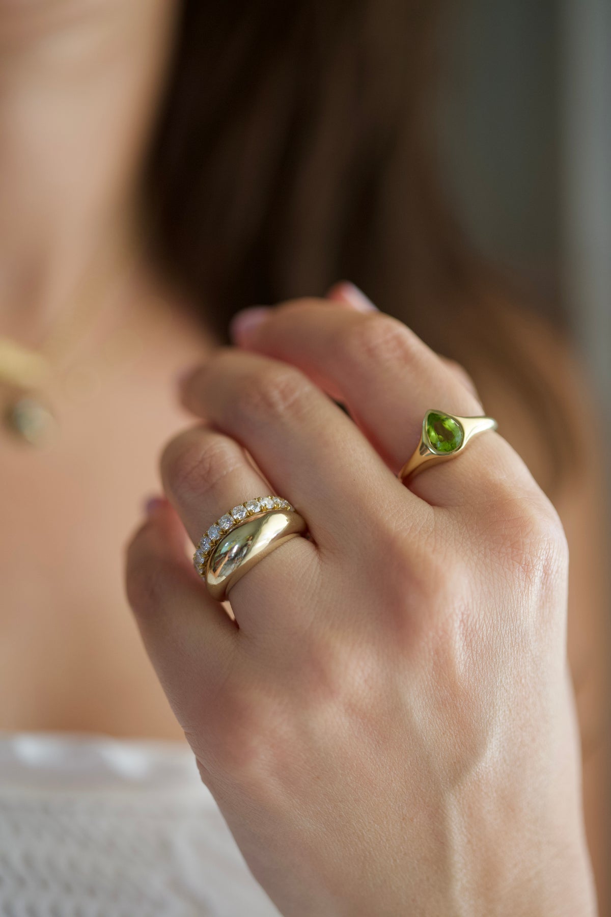 Chunky dome ring in solid yellow gold stacked with a diamond eternity band and a Peridot Signet Ring