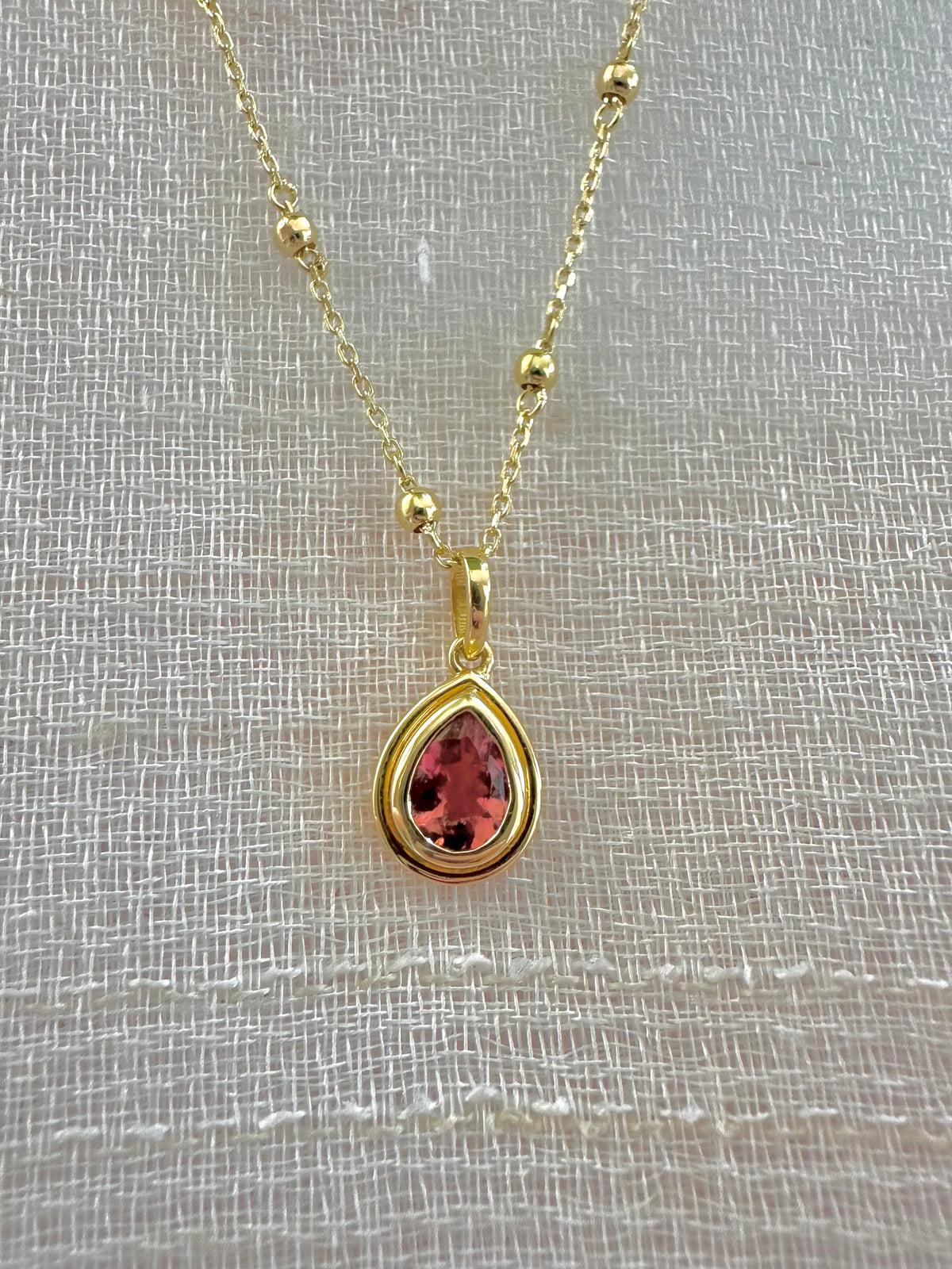 Pear pink tourmaline pendant in a two-tiered gold bezel | Yasmin Nabulsi Fine Jewelry