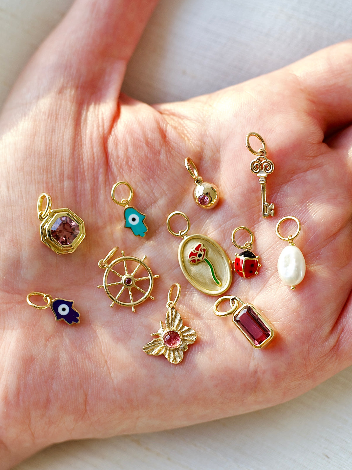 14K gold anchor wheel charm with a 2mm ruby