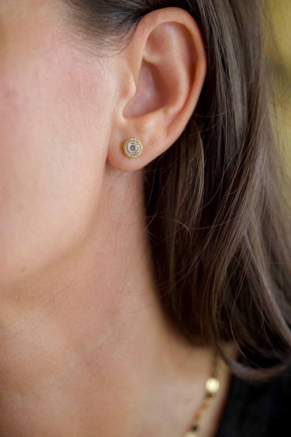 Glypto diamond stud earring, hand carved gold, worn in an ear