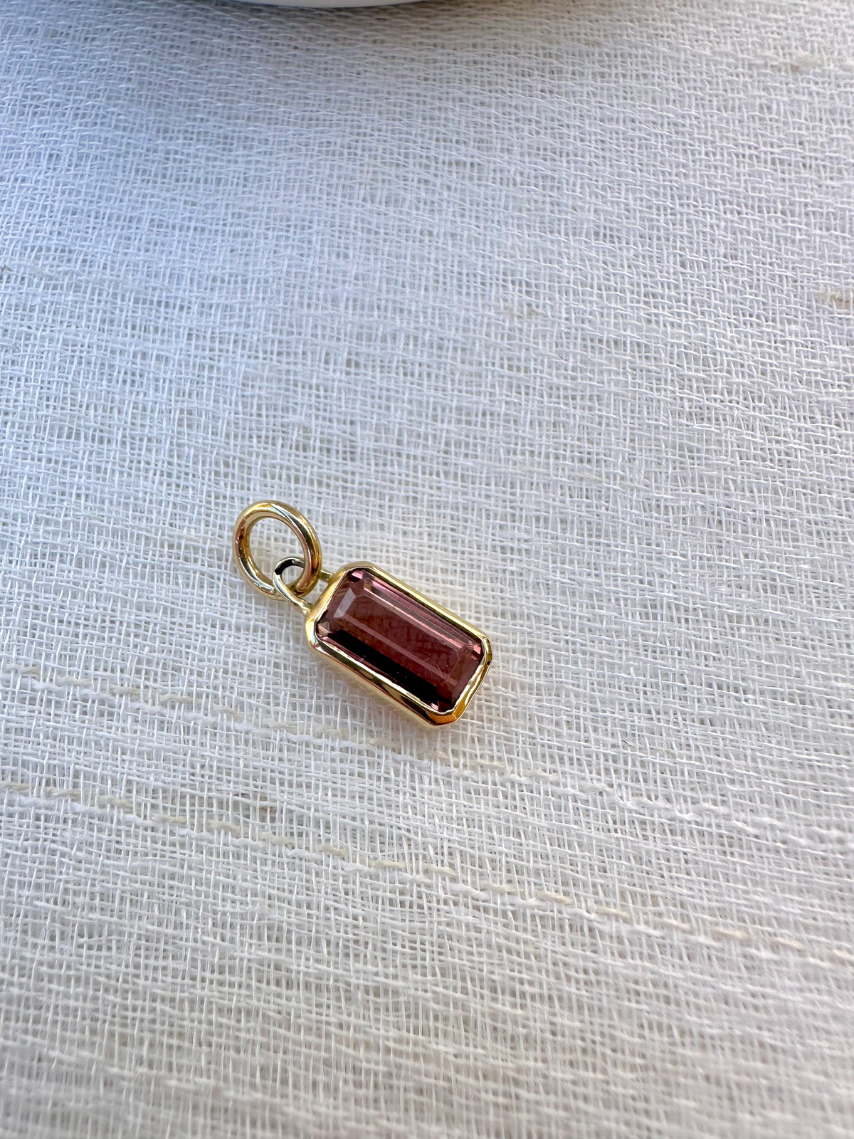 Pink tourmaline charm with a 2 carat emerald cut stone in 18K gold, a further view