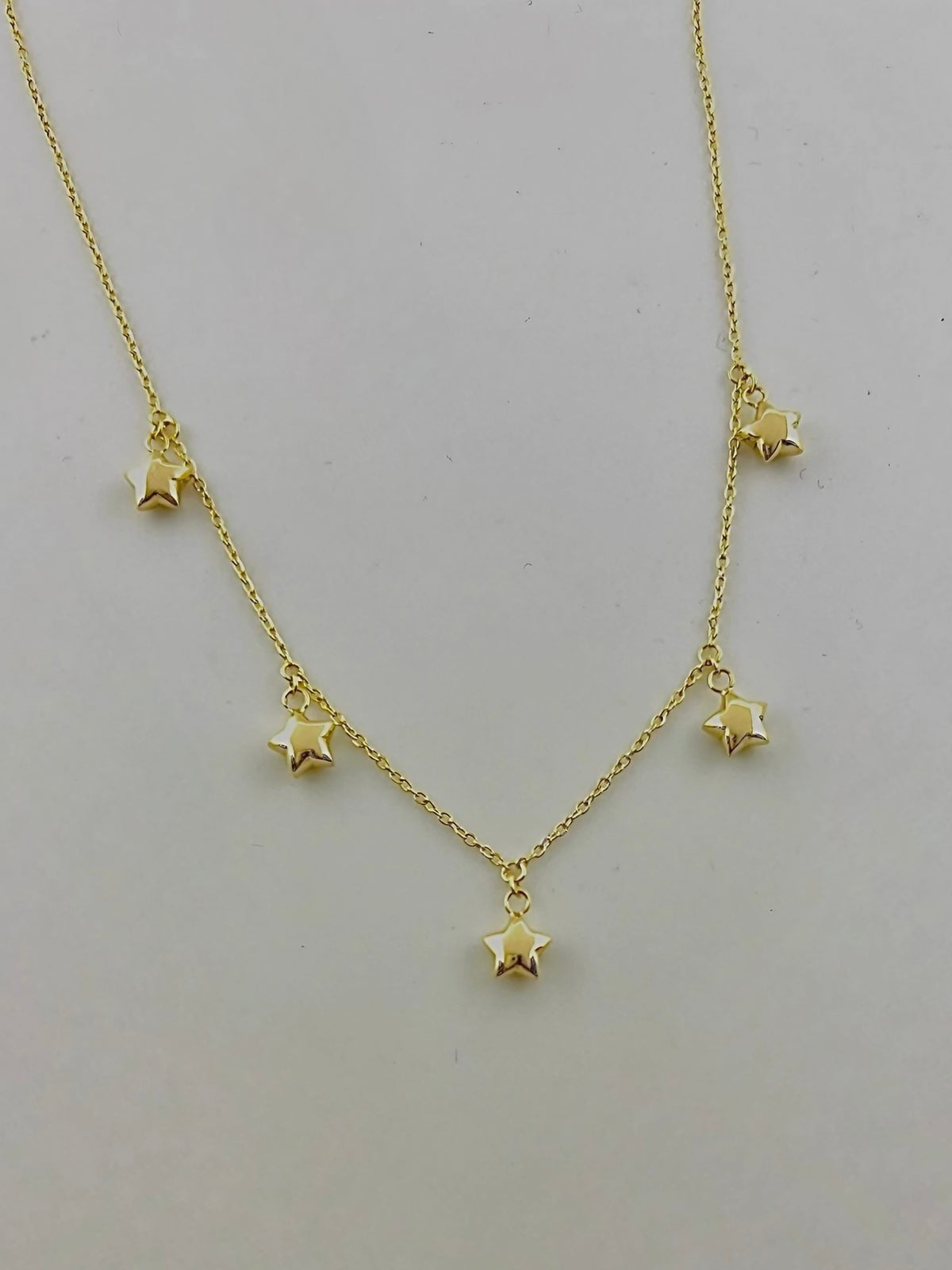 Close-up of the domed puffy star charms in solid 18K gold