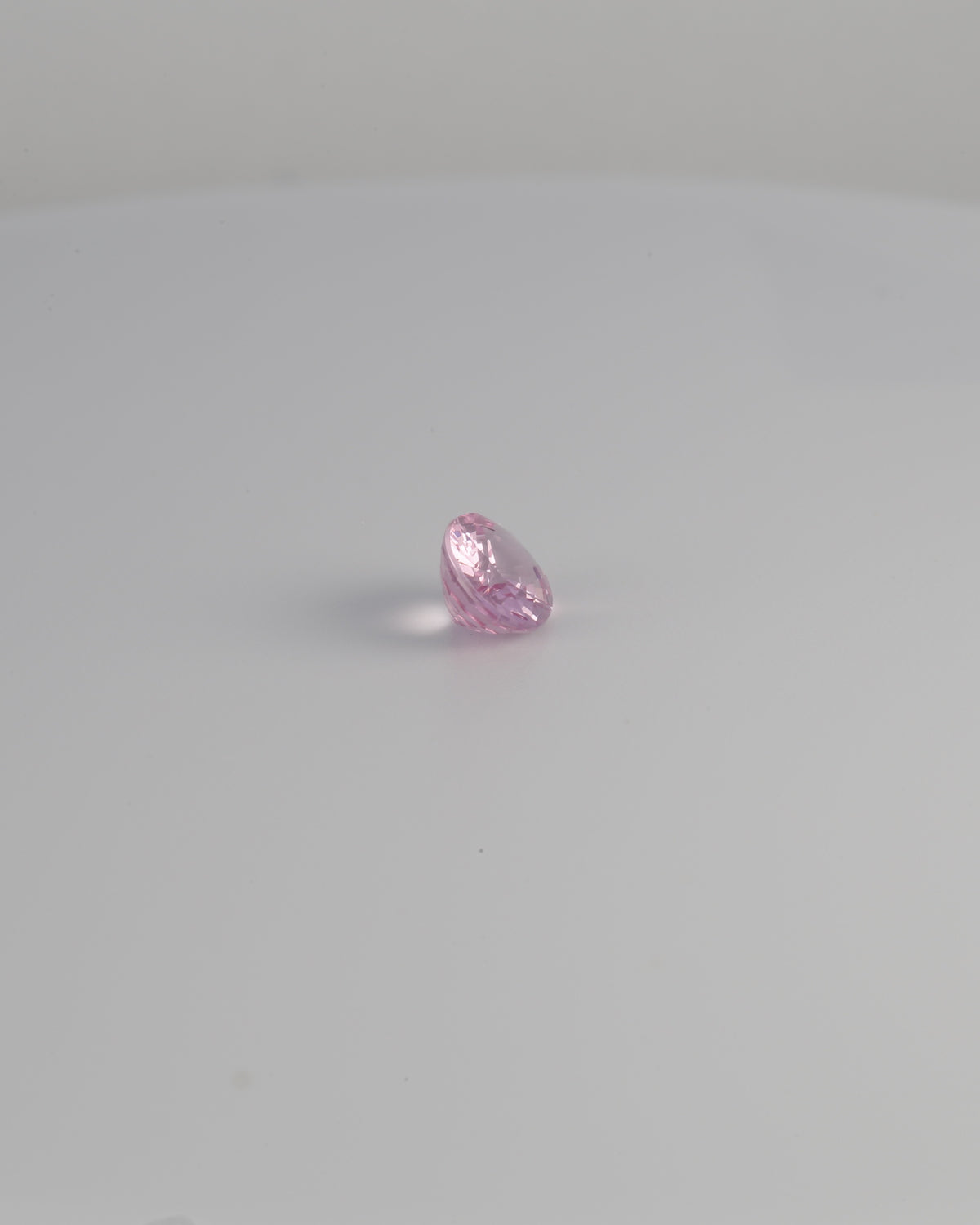 Pink spinel oval gemstone shown at a 90 degree angle