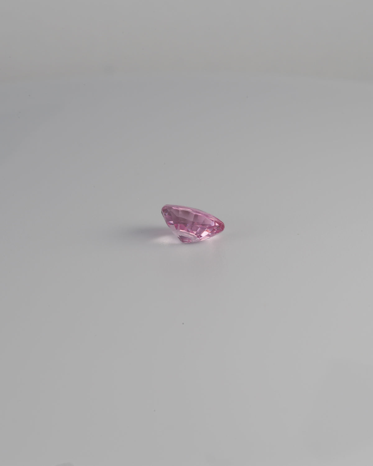 Pink spinel oval gemstone shown at a 160 degree angle
