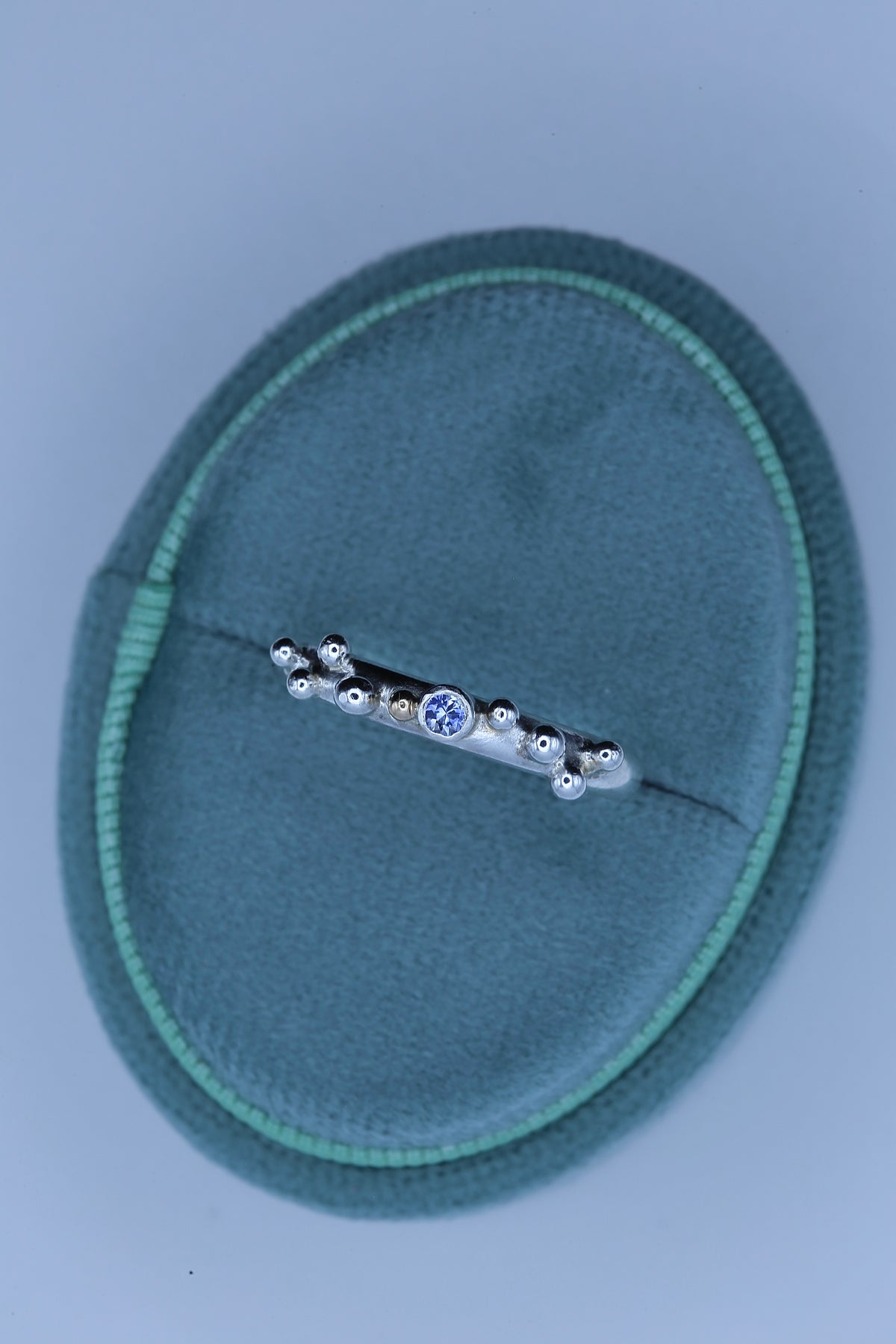 Blue sapphire silver ring with a bezel setting and granulated band