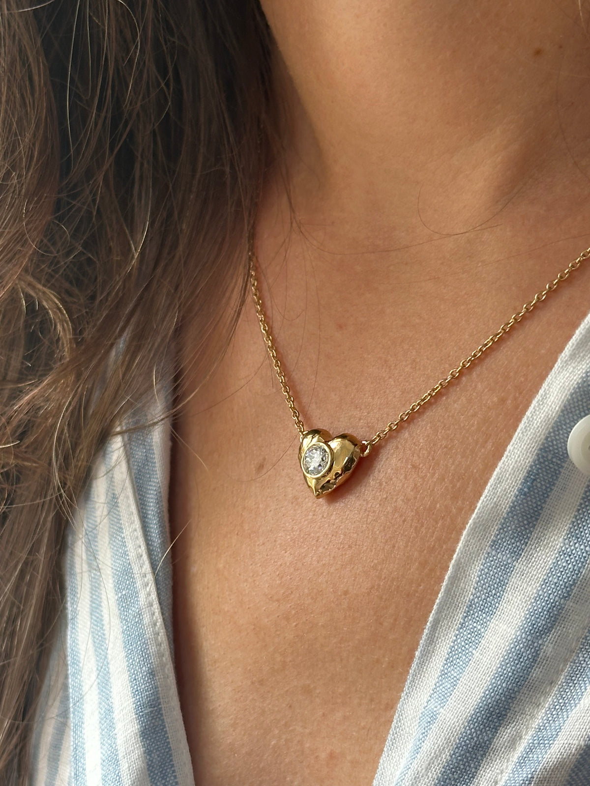 Puffy heart pendant with a bezel set lab diamond and a hammered face