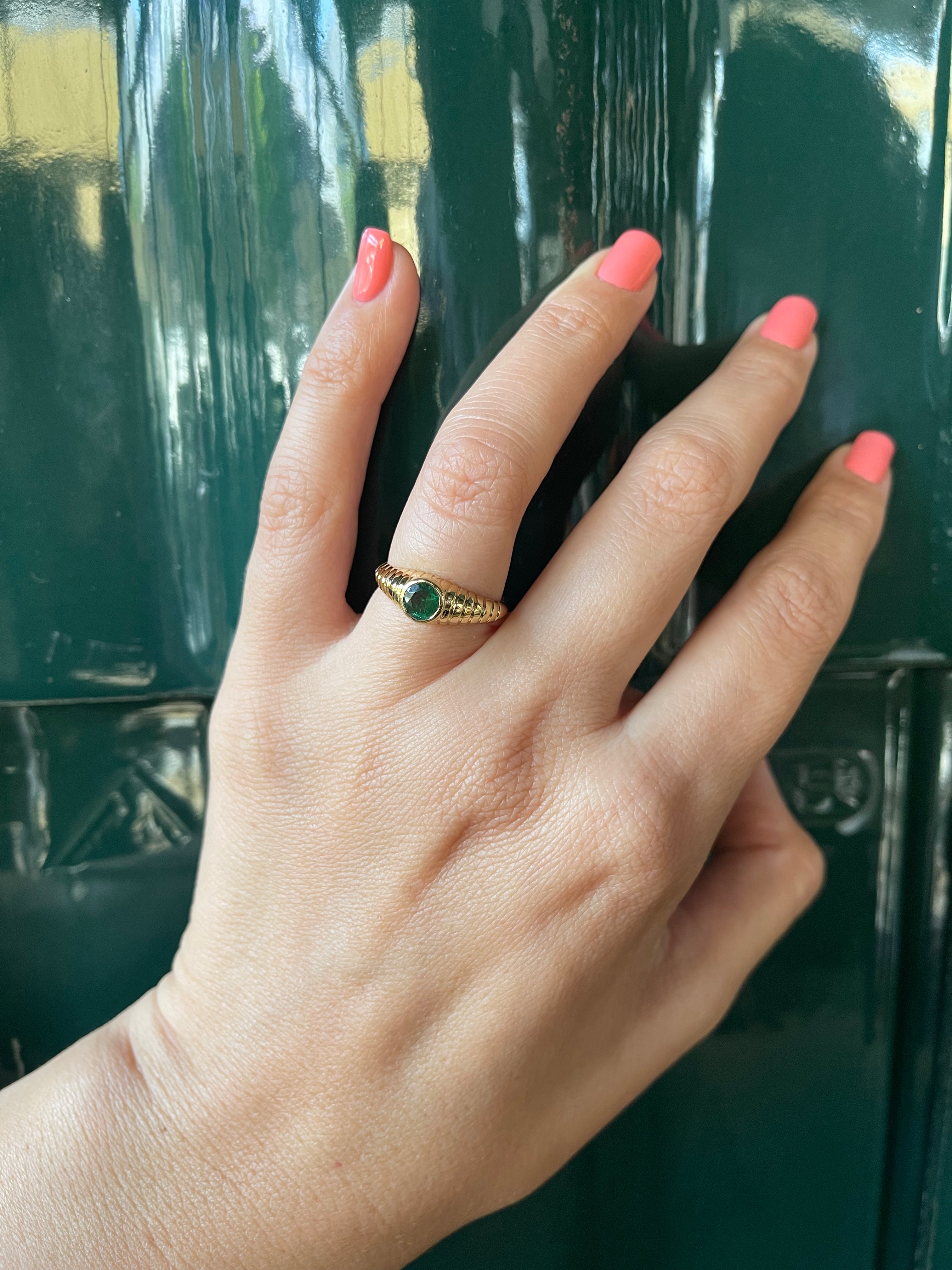 Natural emerald ring in 18K gold with a bezel set center stone and vintage inspired design