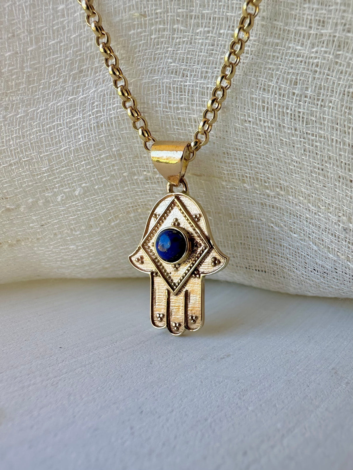 Lapis hamsa pendant with a 4mm natural stone cabochon set in gold