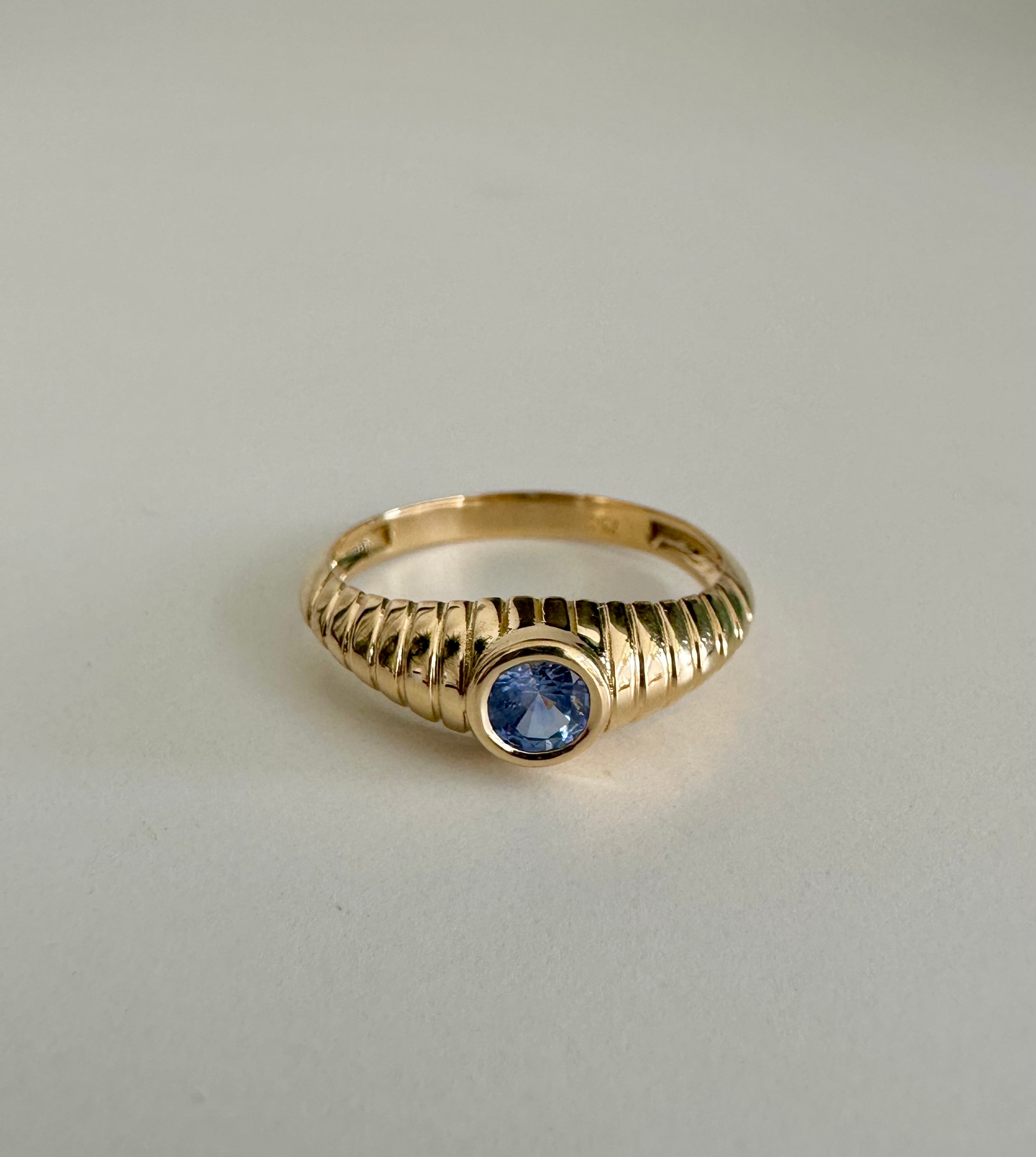 Vintage inspired gold ring with a modern ribbed band and bezel set sapphire