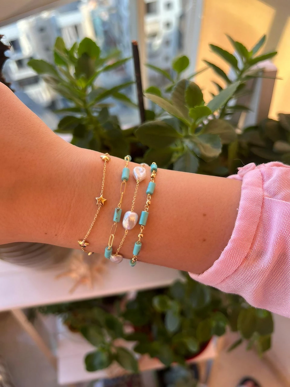 Turquoise bead bracelet in a stack of gold bracelets