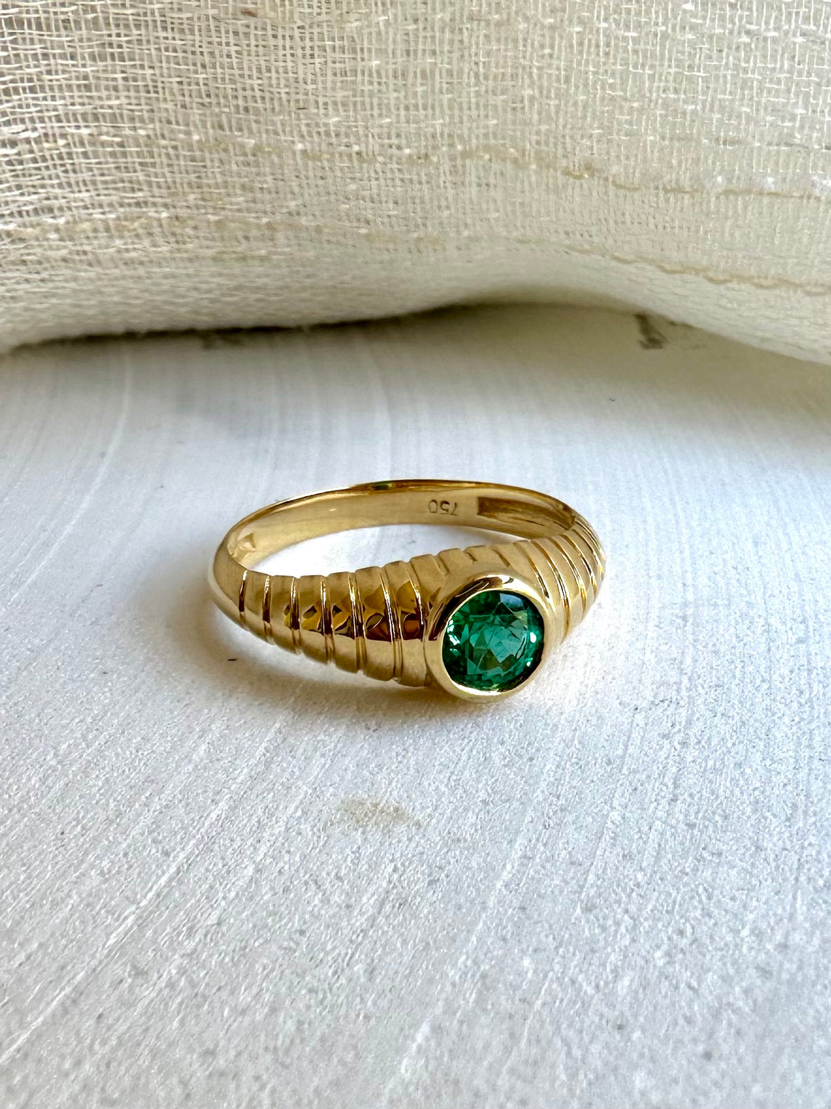 Gold Mina ring with a ribbed band that tapers from about 6.2mm to 2.1mm