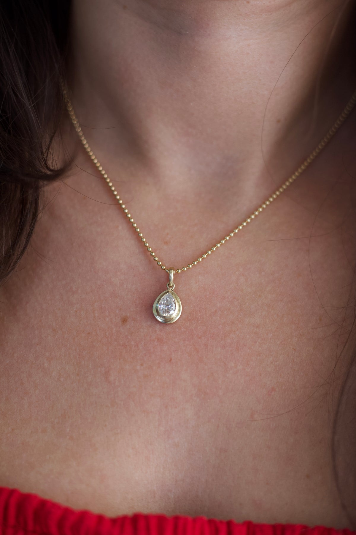 Pear-shaped lab diamond pendant in a satin gold bezel