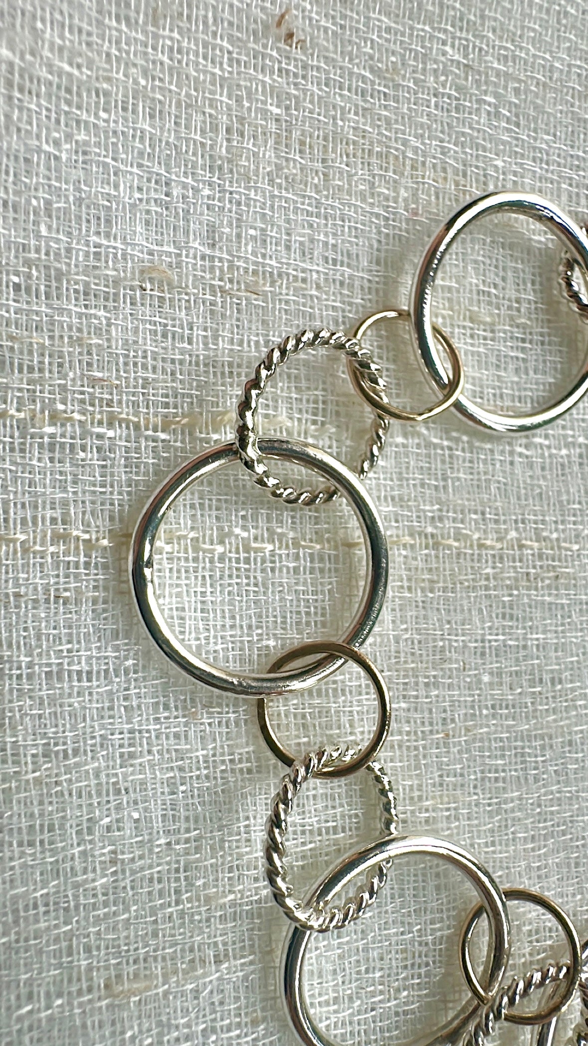 Silver circle links of different sizes and patterns, with 9K gold elements
