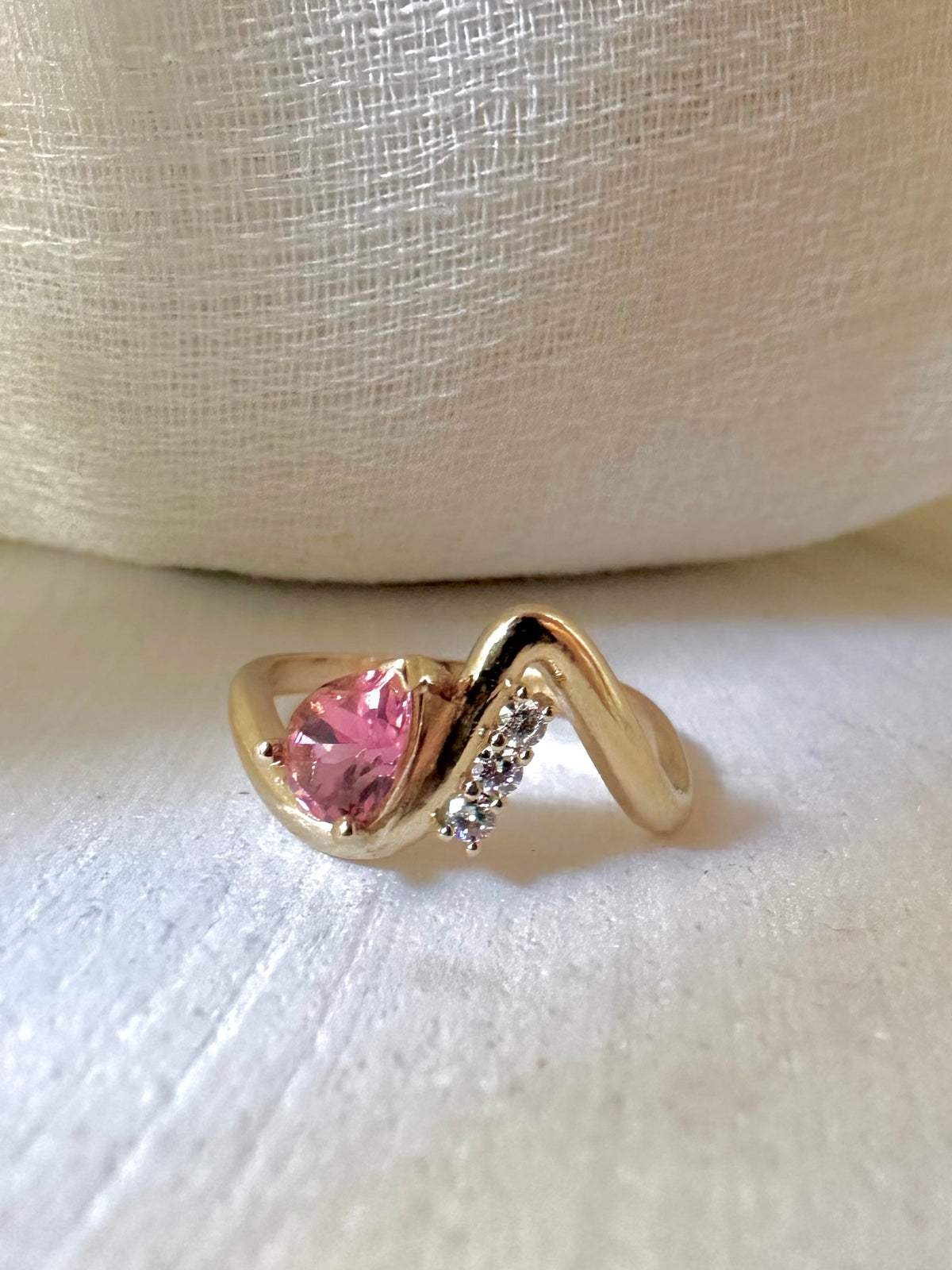 Wave ring in 14K yellow gold with a pear shaped center stone and accent lab diamonds