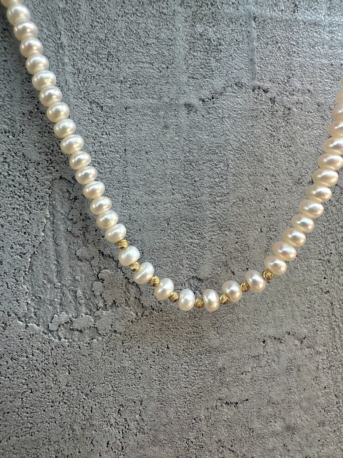 Pearl choker showing the center gold beads and a single pearl separator