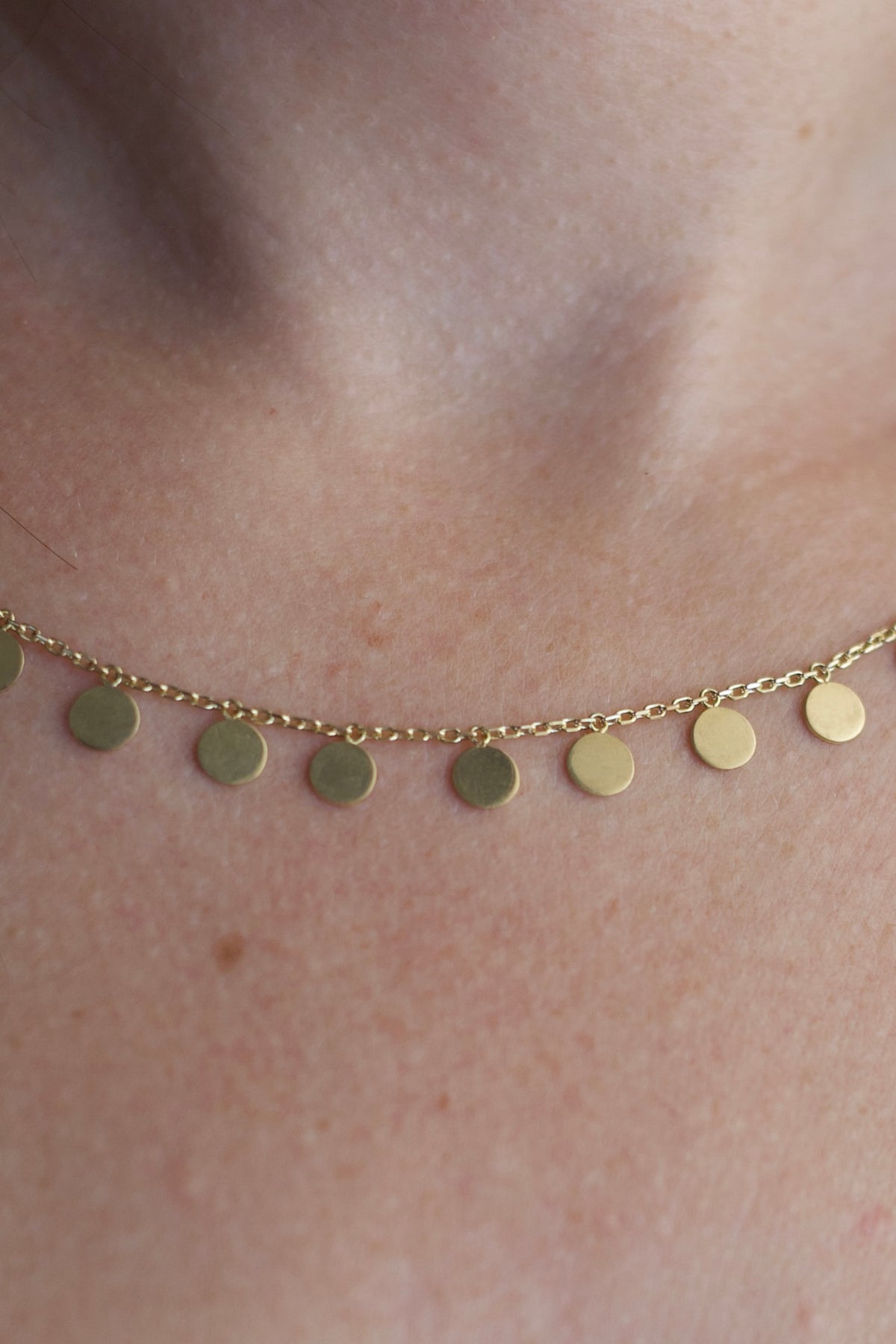 Nineteen 5mm gold discs freely dangling along a 1.2mm cable chain