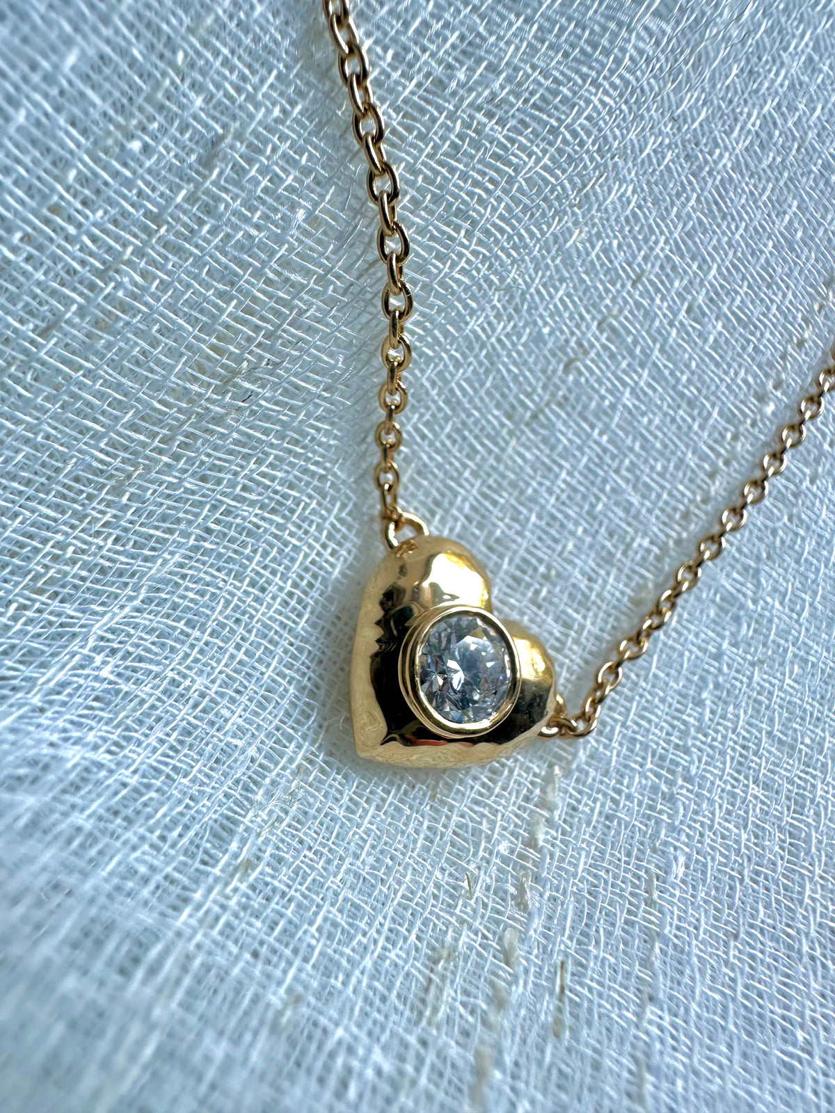 Side profile of the puffy heart pendant showing its depth and flat back