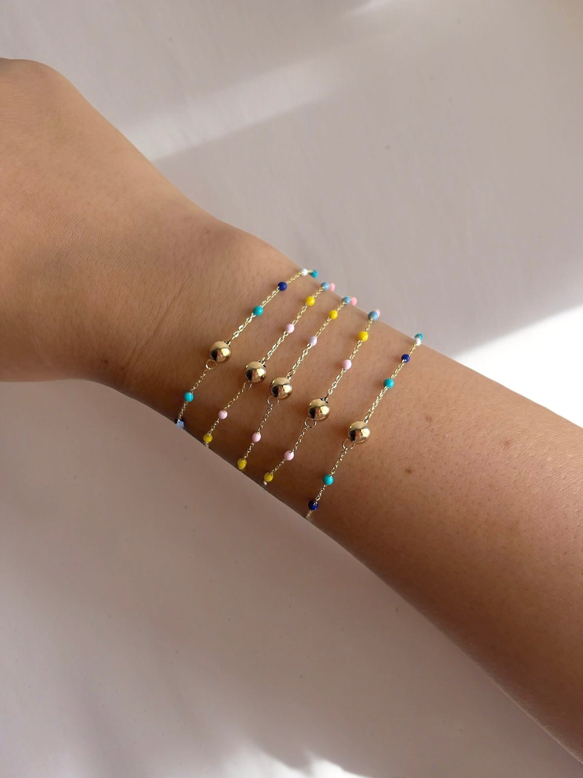 18K gold ball bracelet with a gold bead at the center and enamel beads spaced along the chain | Yasmin Nabulsi Fine Jewelry