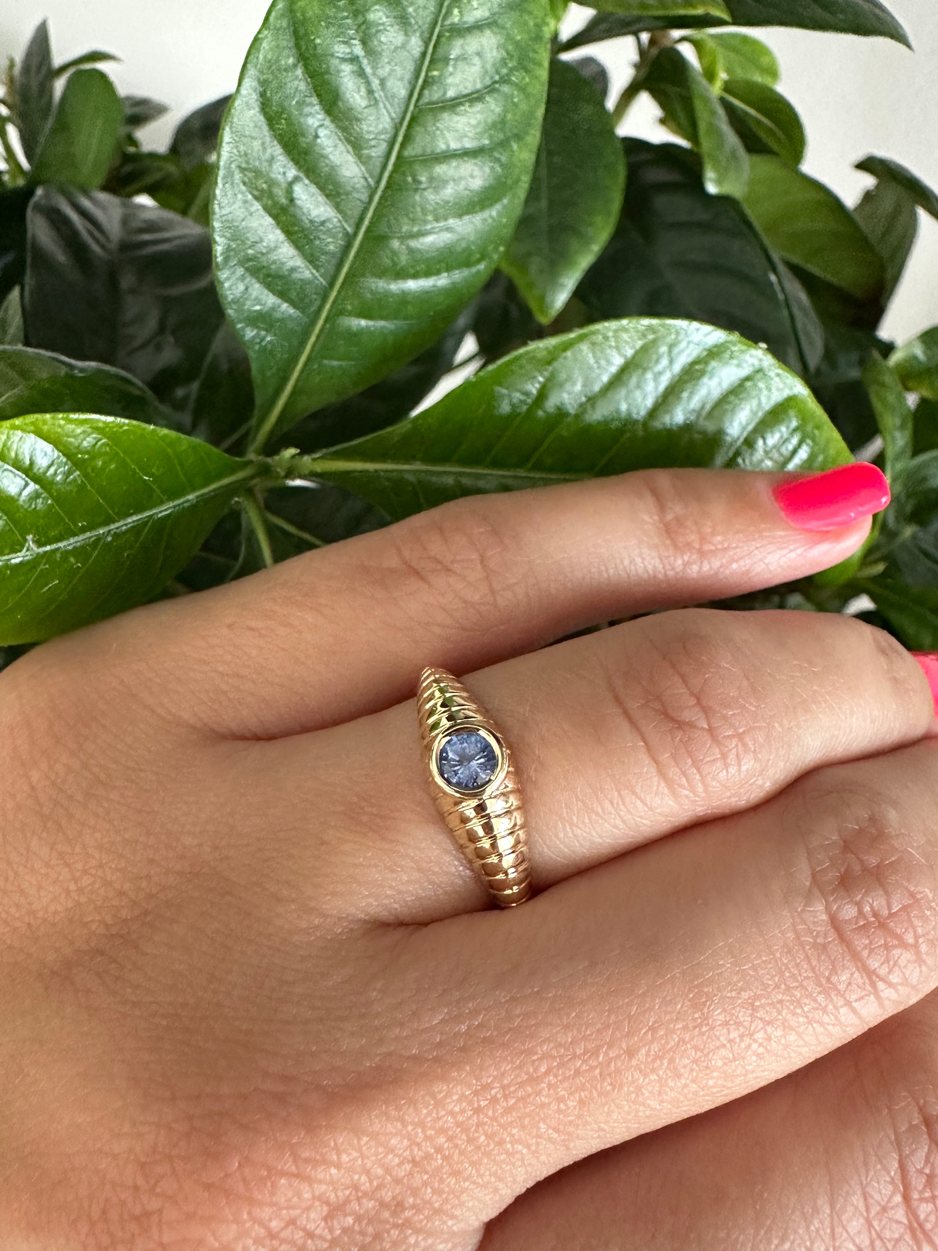 Gold sapphire ring with an intricate ribbed pattern band