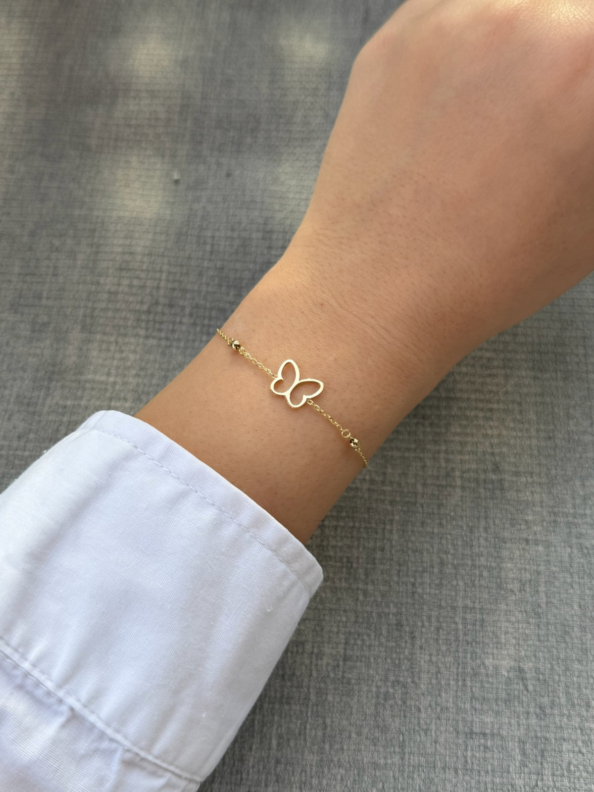 Butterfly bracelet with gold beads accenting the fine chain