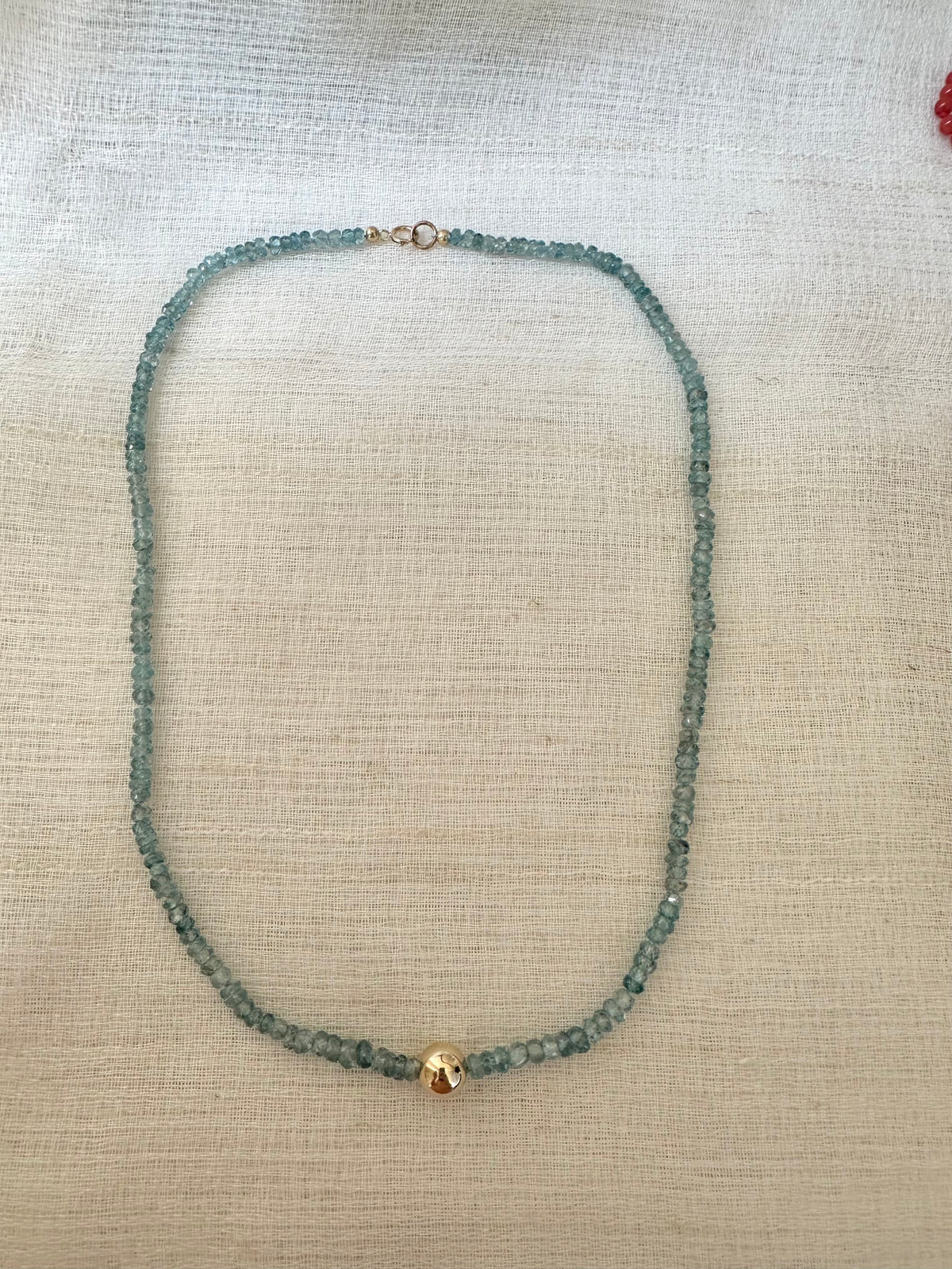 8mm 14K solid gold center bead on a blue zircon necklace
