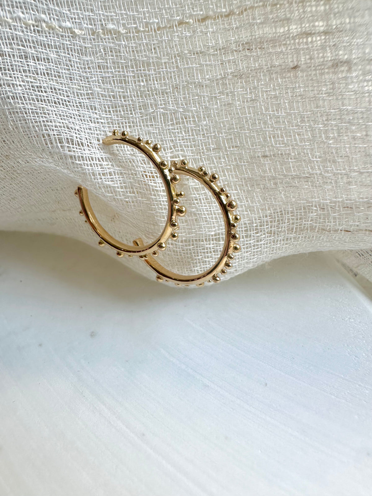 Solid gold hoop with a 16mm round shape and a push back closure