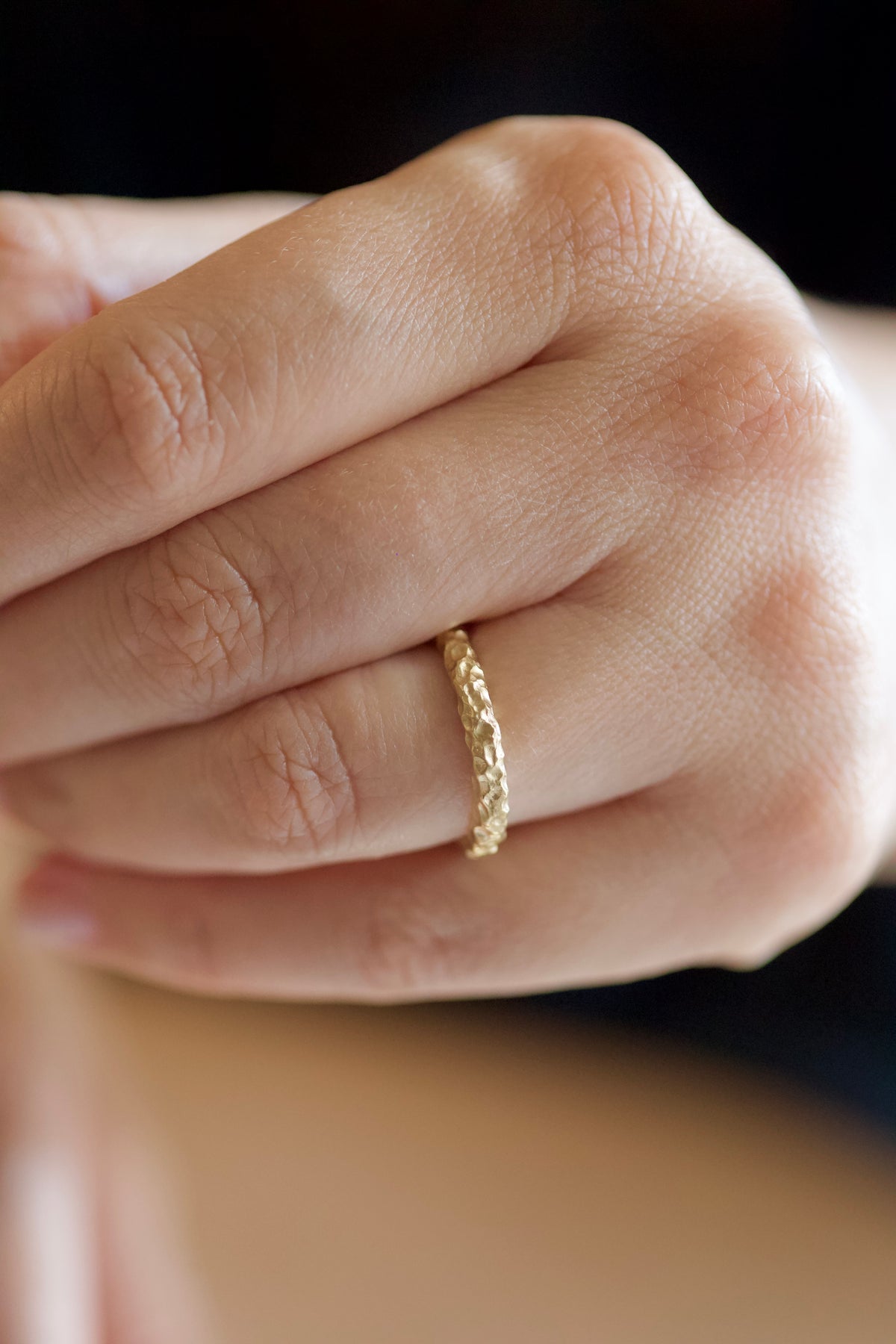 Glypto Band, hammered gold ring worn on a finger