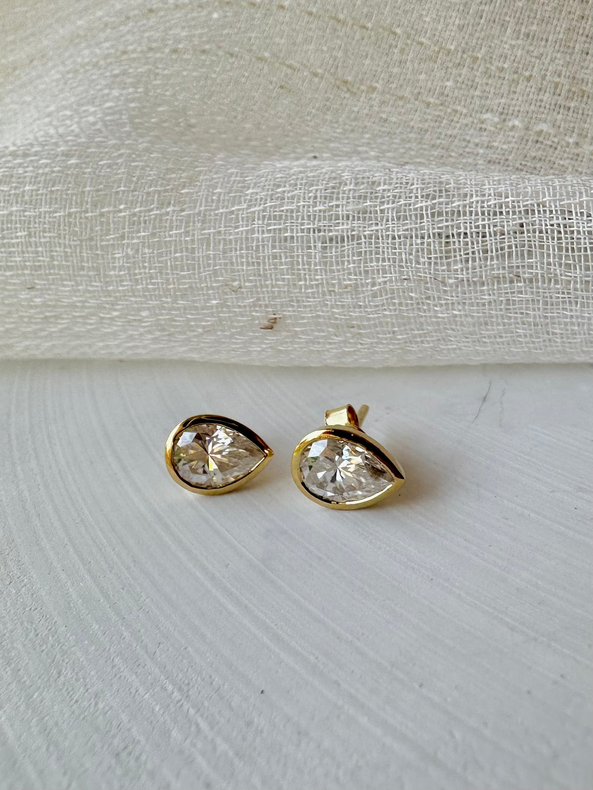Pear stud earring about 8.5 by 6.5mm, with a 7 by 5mm moissanite