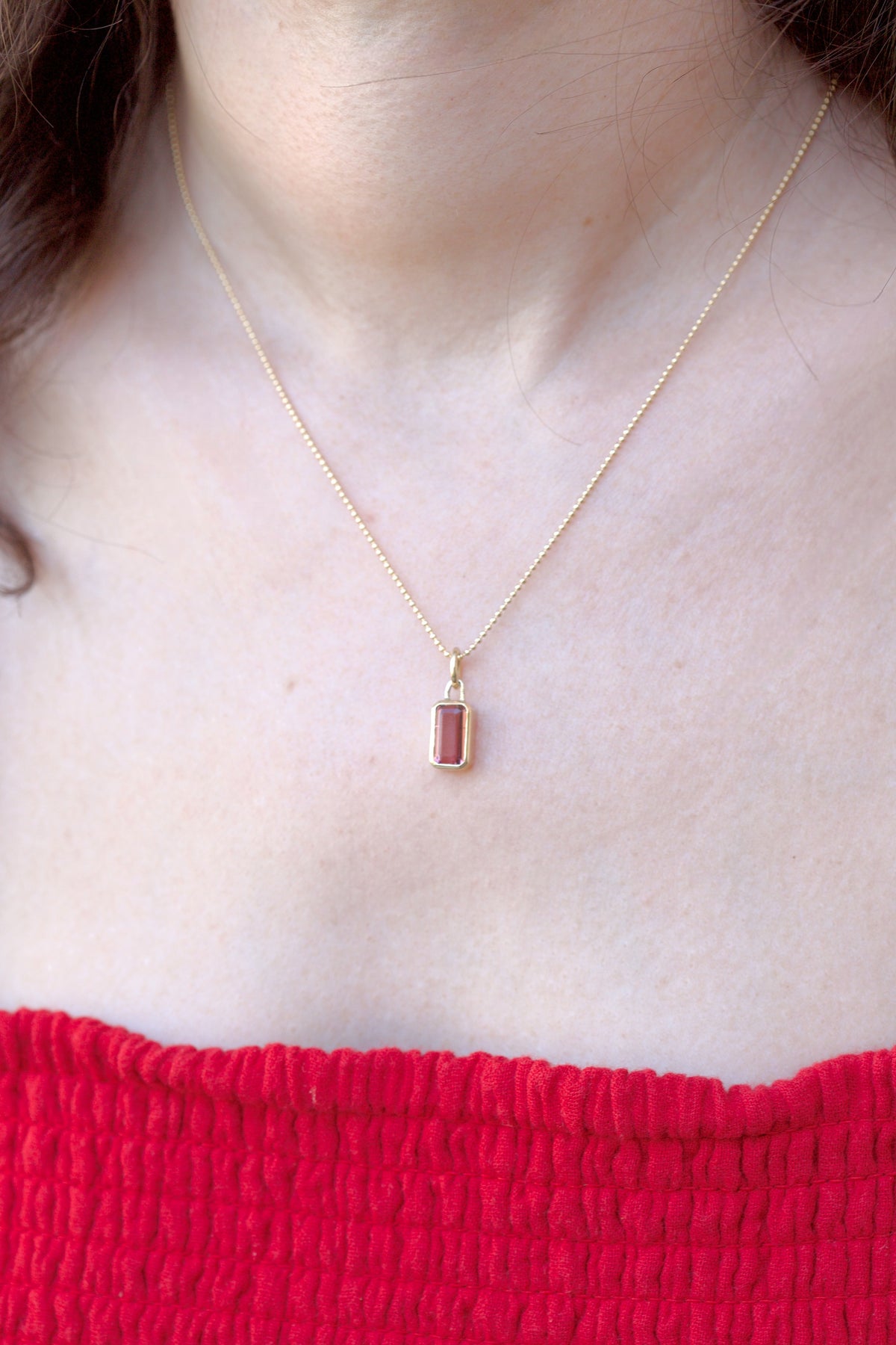 Pink tourmaline charm in 18K gold, shown from another angle