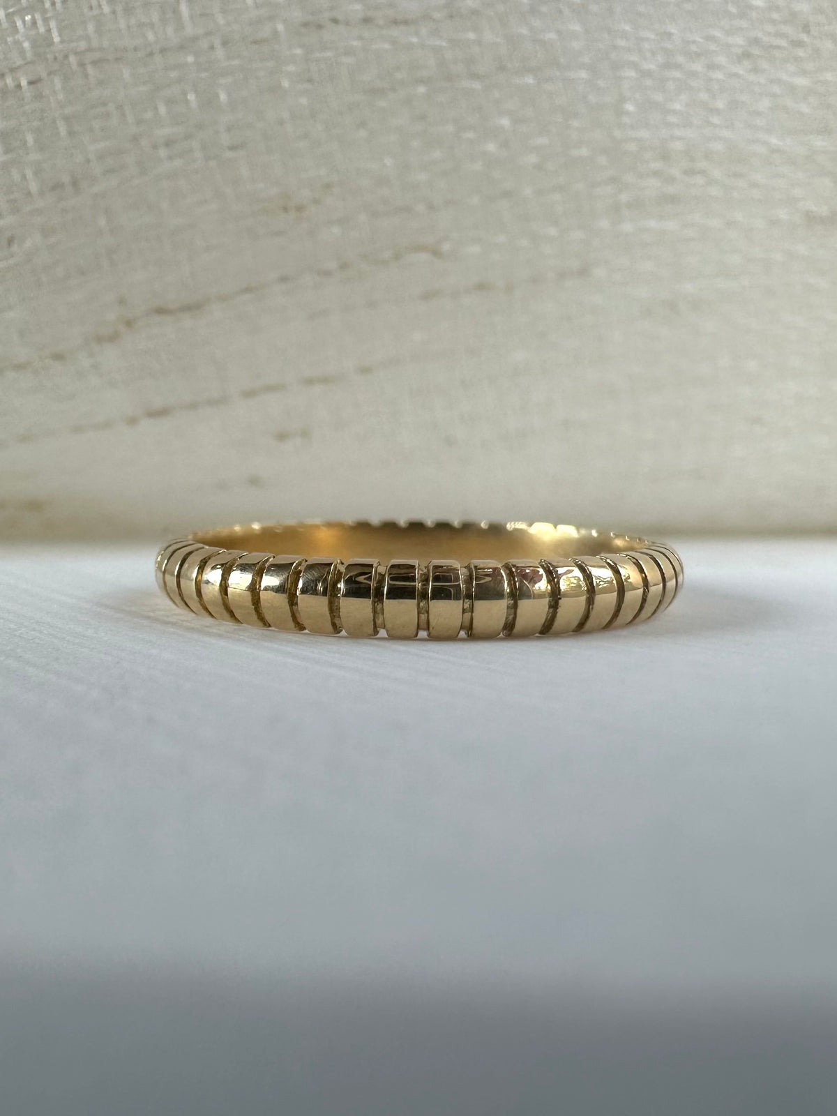 Thin 18K solid gold ribbed wedding band worn on a finger | Yasmin Nabulsi Fine Jewelry