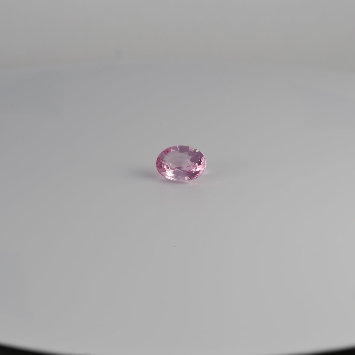 Oval pink spinel gemstone viewed from an angle