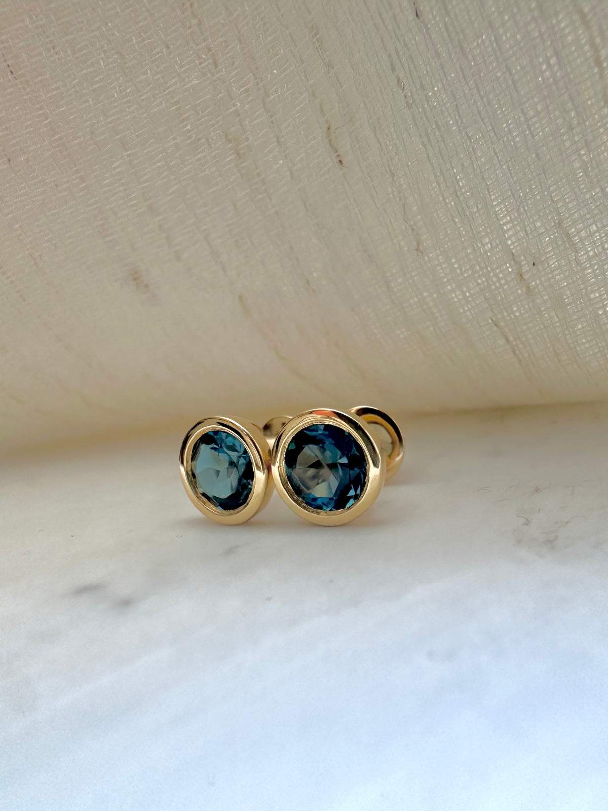 London blue topaz studs in 18 karat yellow gold, shown from another angle