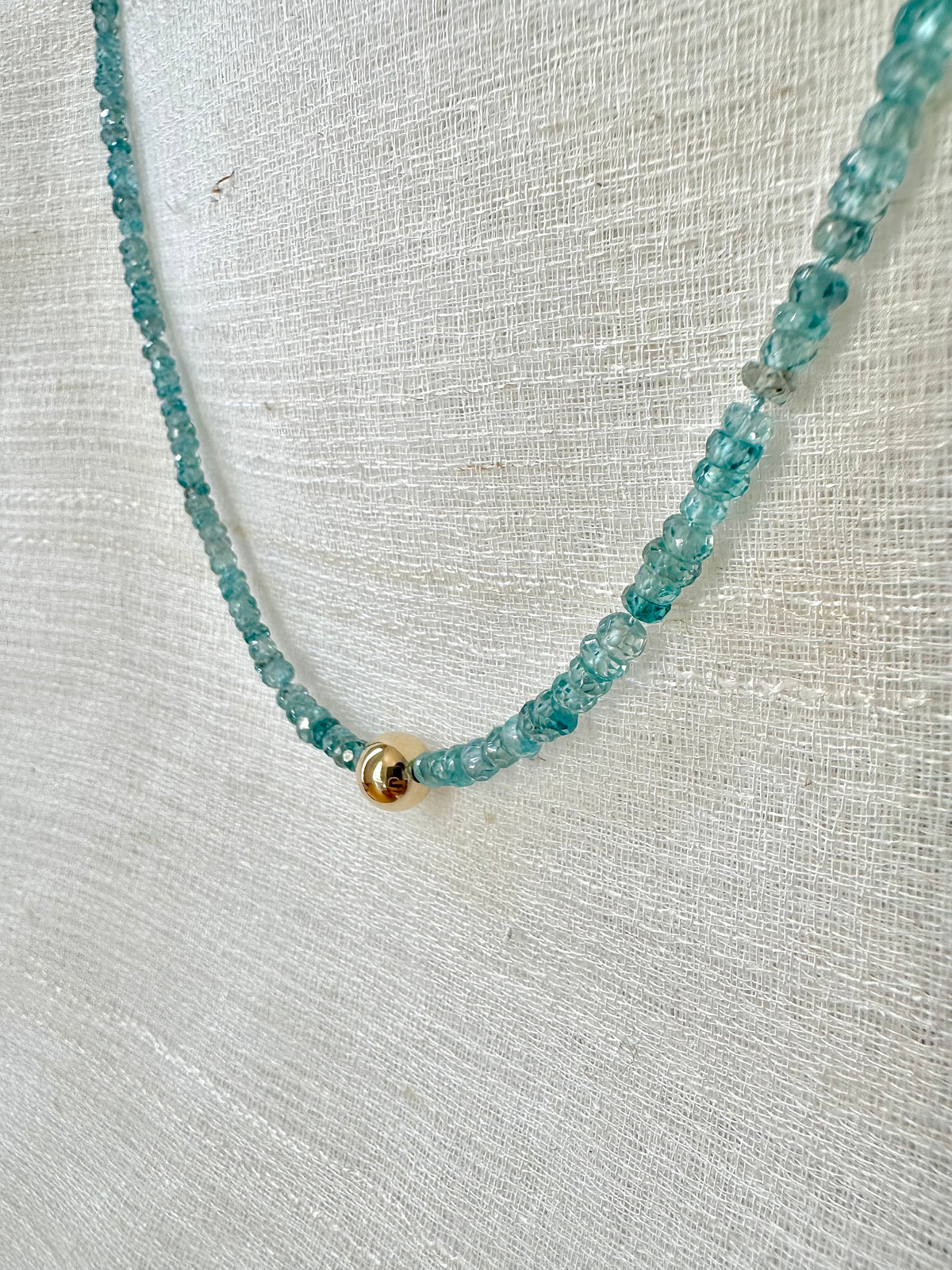 Natural blue zircon beads, 2 to 3mm, strung on silk thread