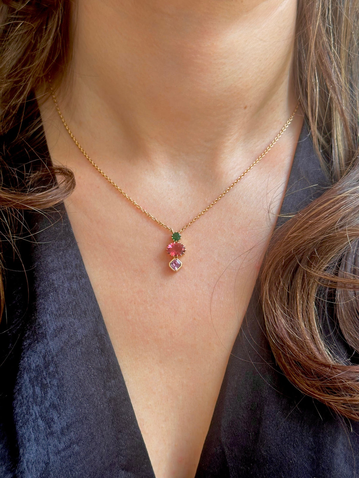 Emerald, tourmaline and sapphire pendant on an 18K gold necklace