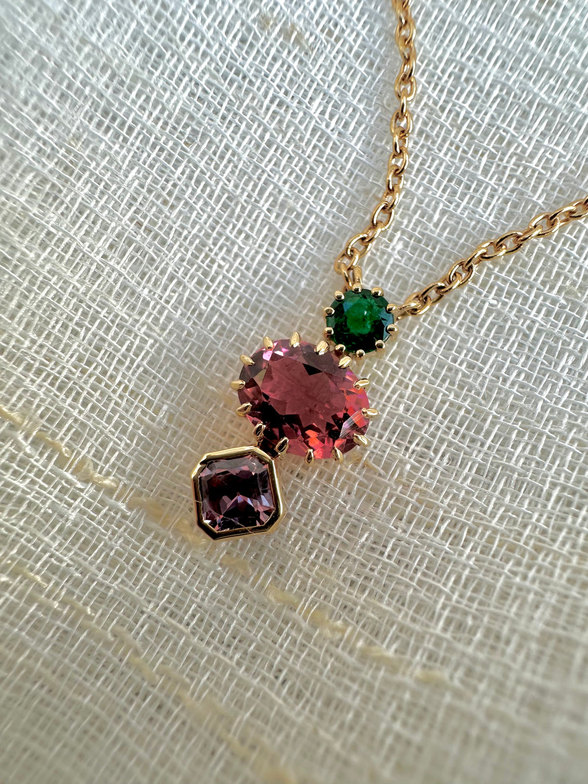 Cluster gemstone necklace with an emerald, tourmaline and sapphire pendant