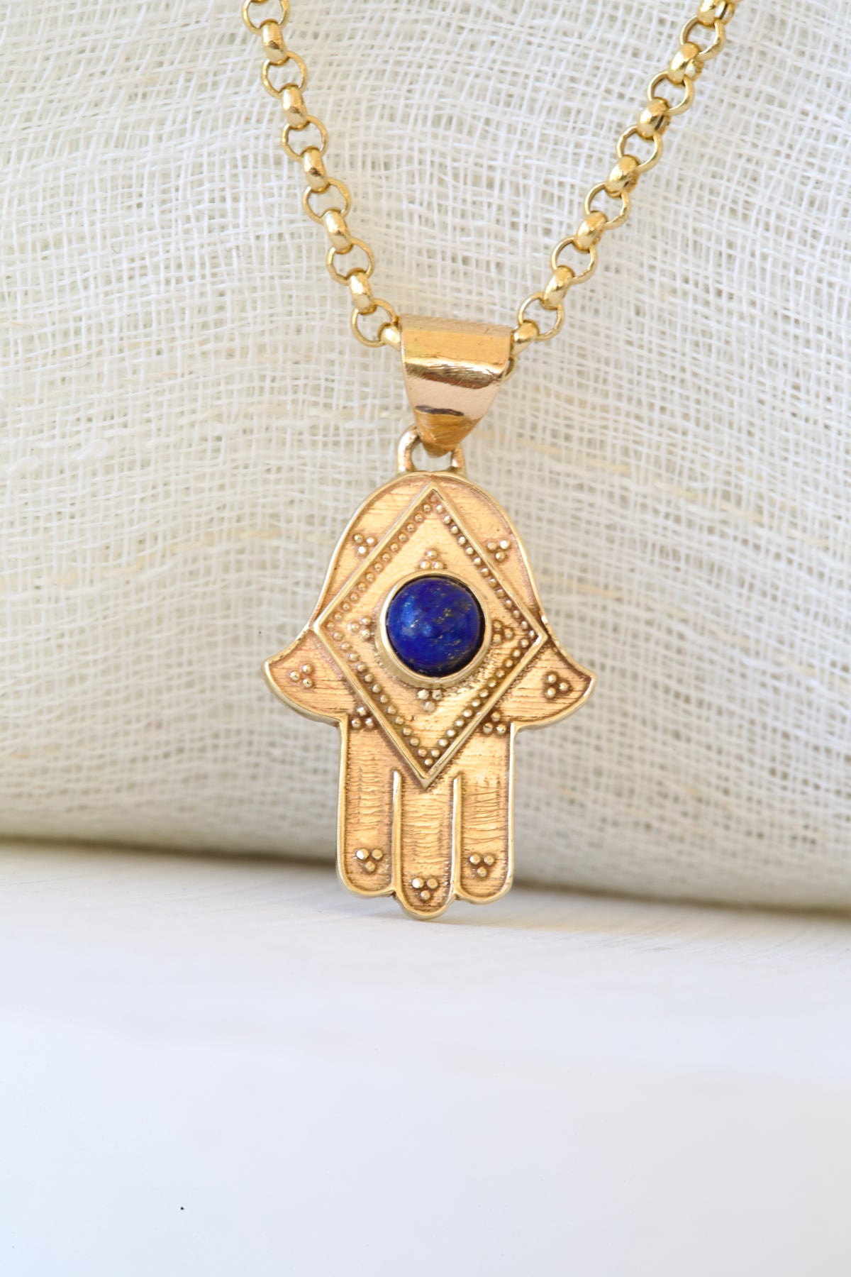 Gold hamsa hand pendant with a lapis lazuli stone at the center, in 14K or 18K gold | Yasmin Nabulsi Fine Jewelry