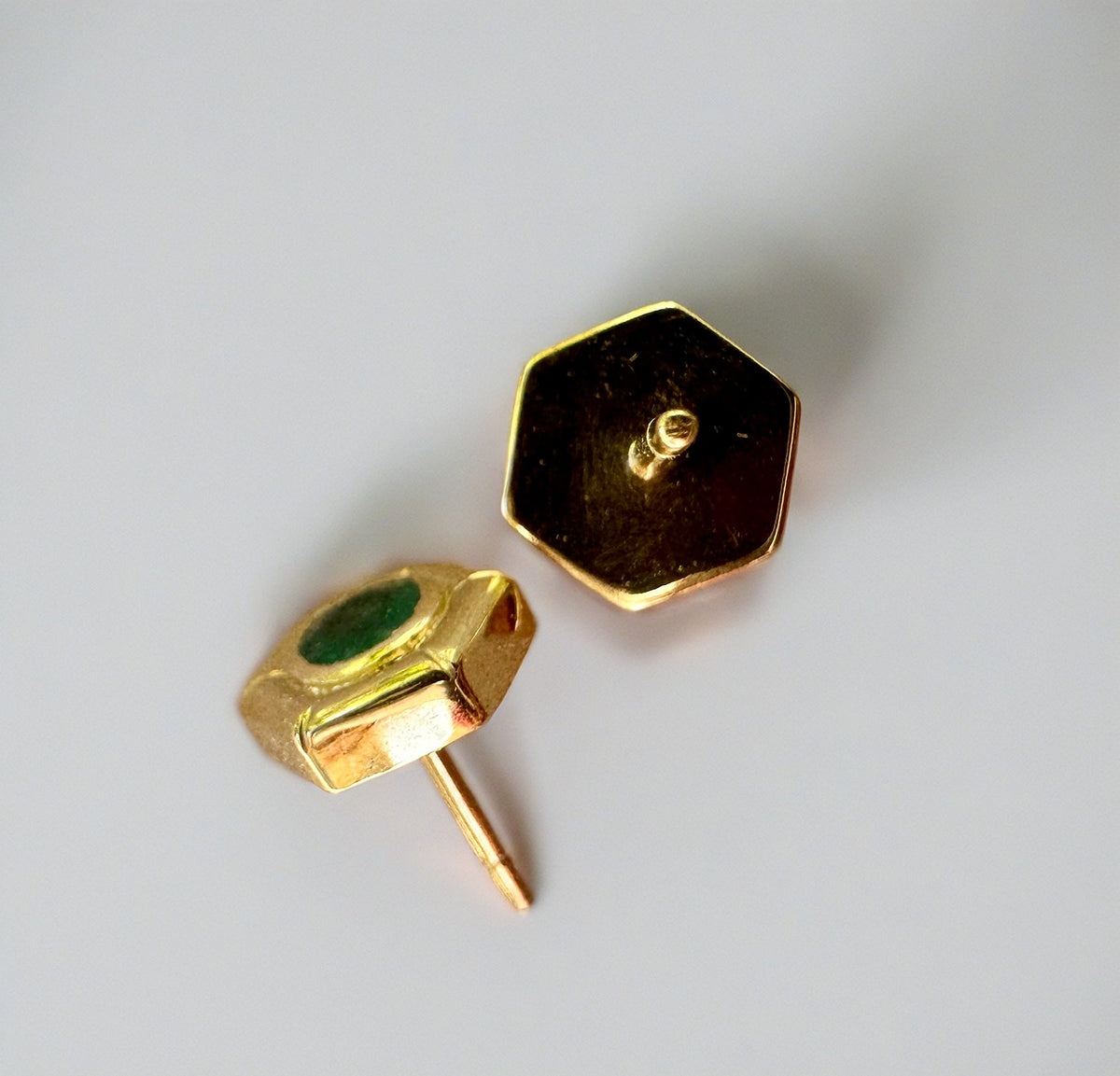 Hexagon emerald stud earrings with a bezel-set center emerald