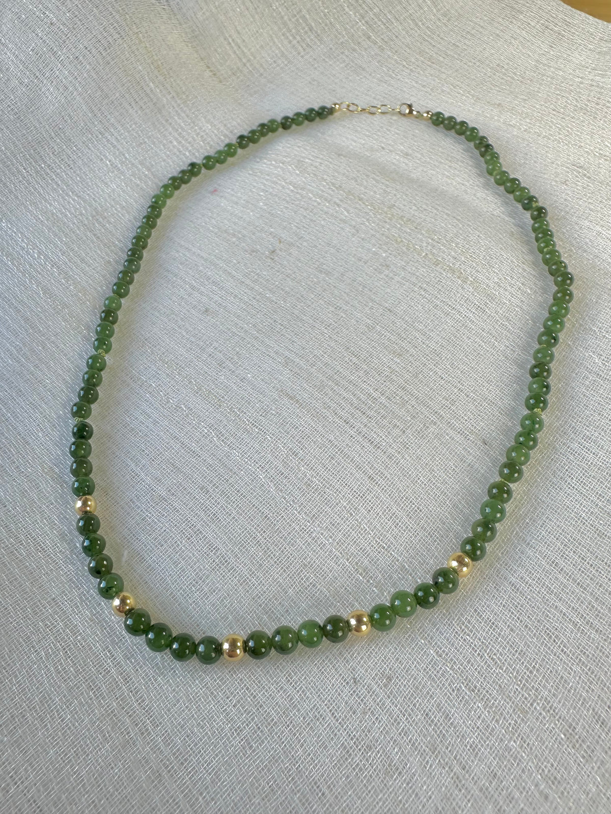 Natural Canadian jade beads strung with five 18K solid gold beads on silk thread