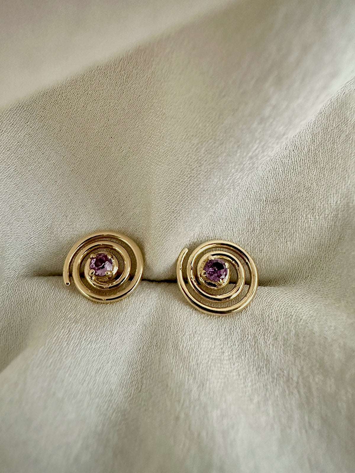 Purple sapphire spiral studs in 18K yellow gold