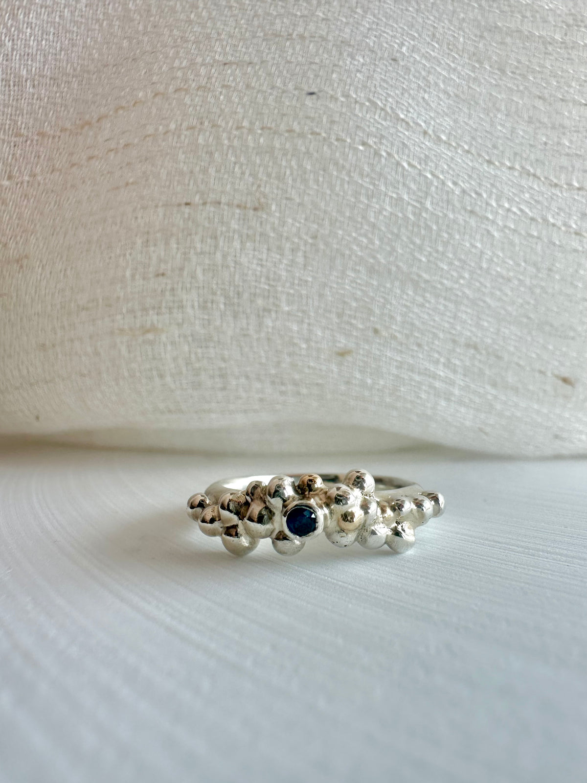 Recycled sterling silver ring with granules and a blue sapphire bezel set at the center | Yasmin Nabulsi Fine Jewelry