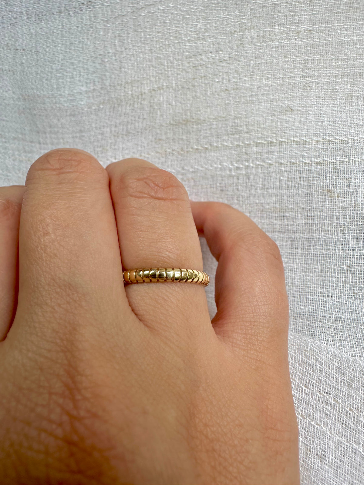 Handcrafted thin gold ring with a polished ribbed texture