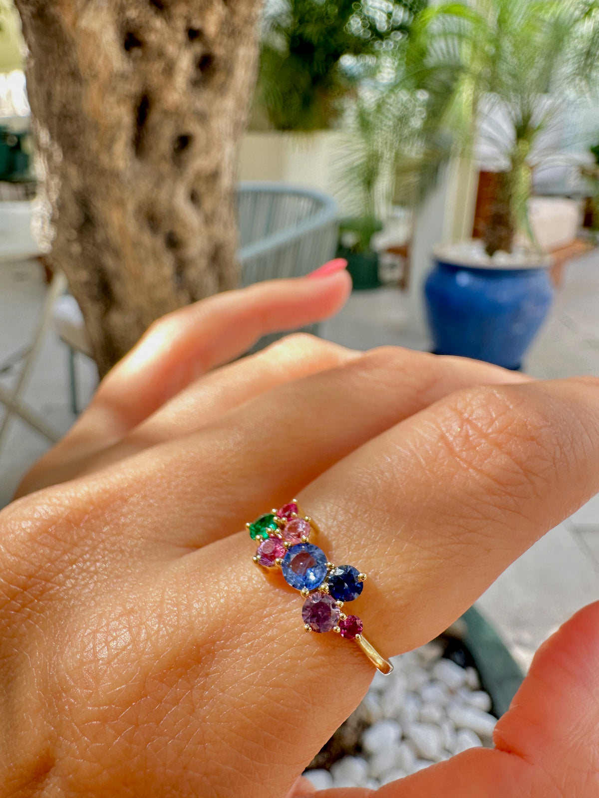 Rainbow cluster ring of natural multicolor sapphires and one natural emerald on a dainty 18K gold band